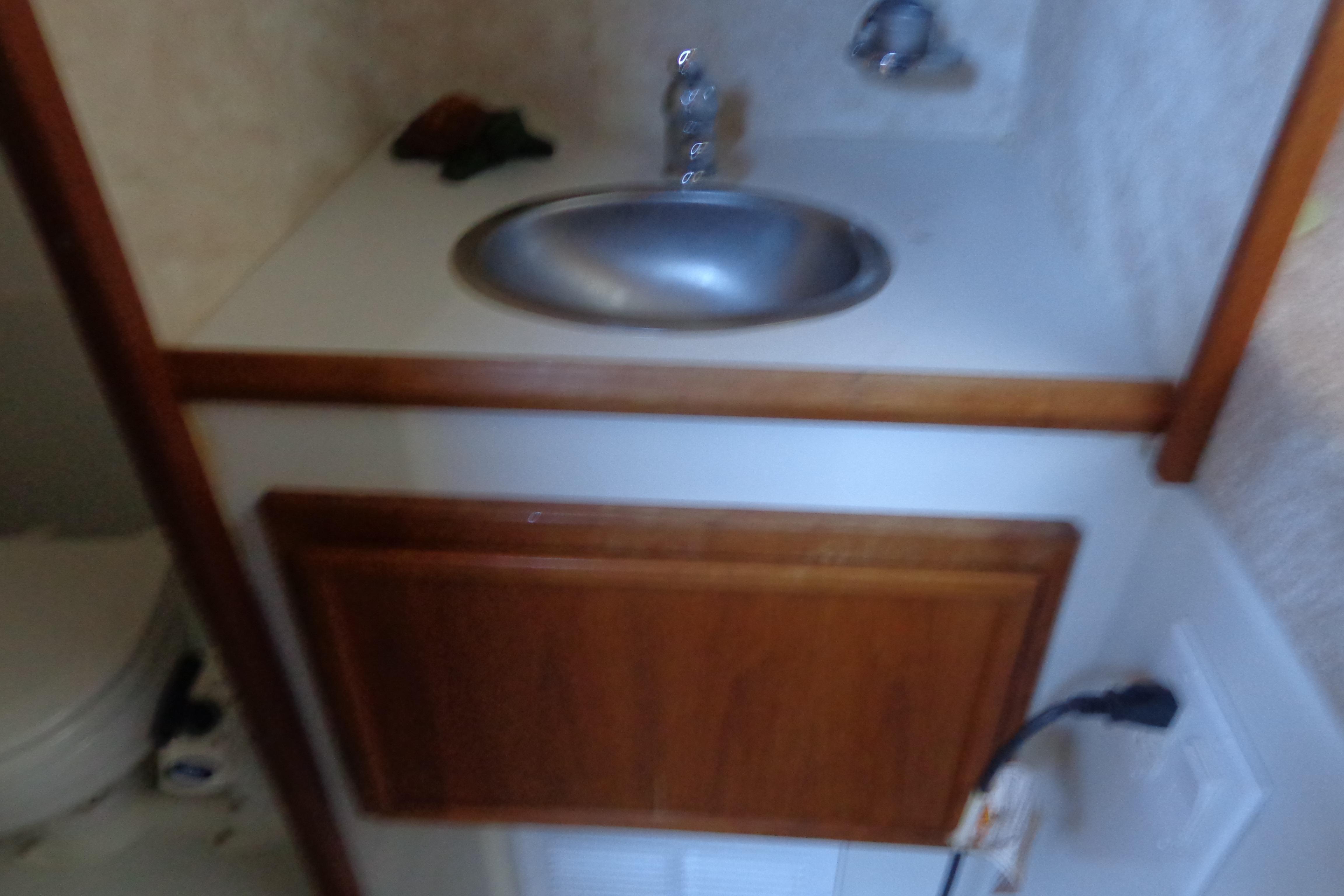 1992 Cruise-A-Home Corsair 4200 bathroom sink with wooden cabinet and faucet.