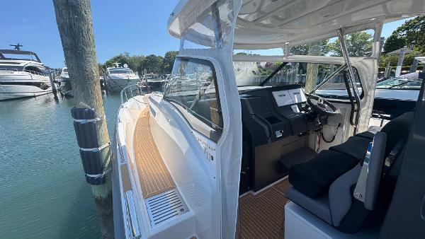 2025 Nimbus T11 boat interior with modern dashboard, docked at marina.