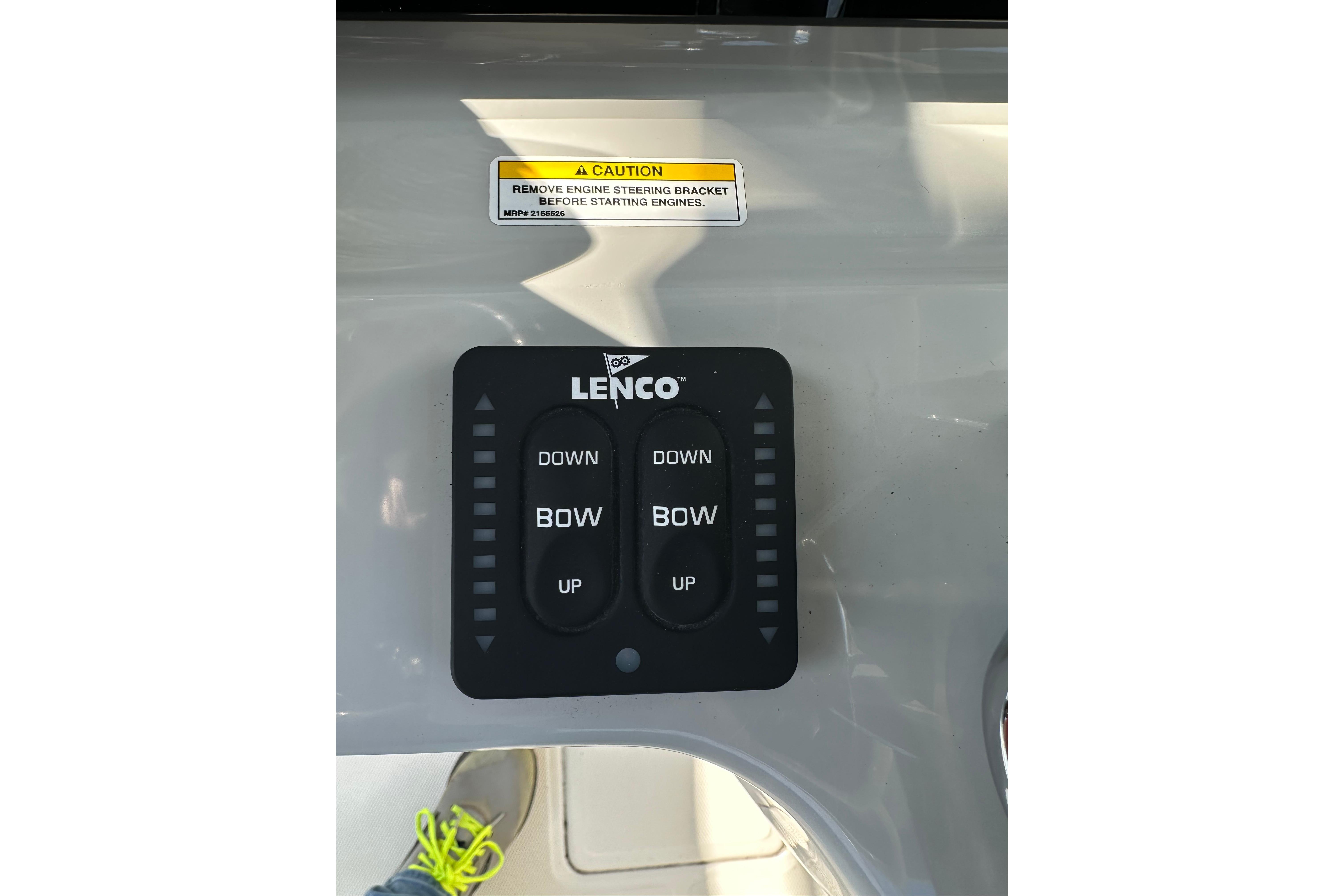 Control panel of a 2023 Boston Whaler 330 Outrage boat with Lenco trim tab switches.