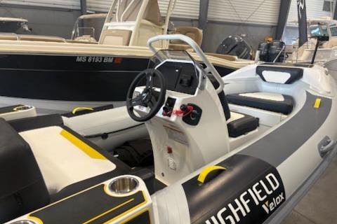 2026 Highfield Velox 420 boat interior with steering console and seating in showroom.