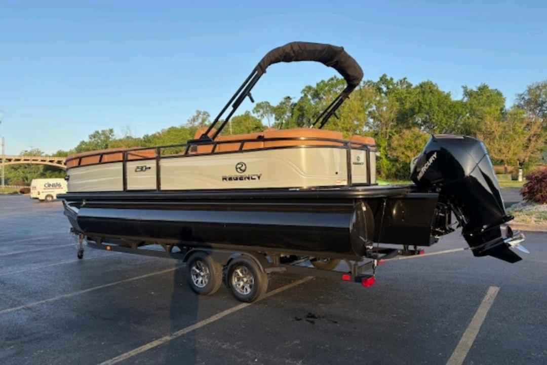 2026 Regency 230 DL pontoon boat on trailer in parking lot.