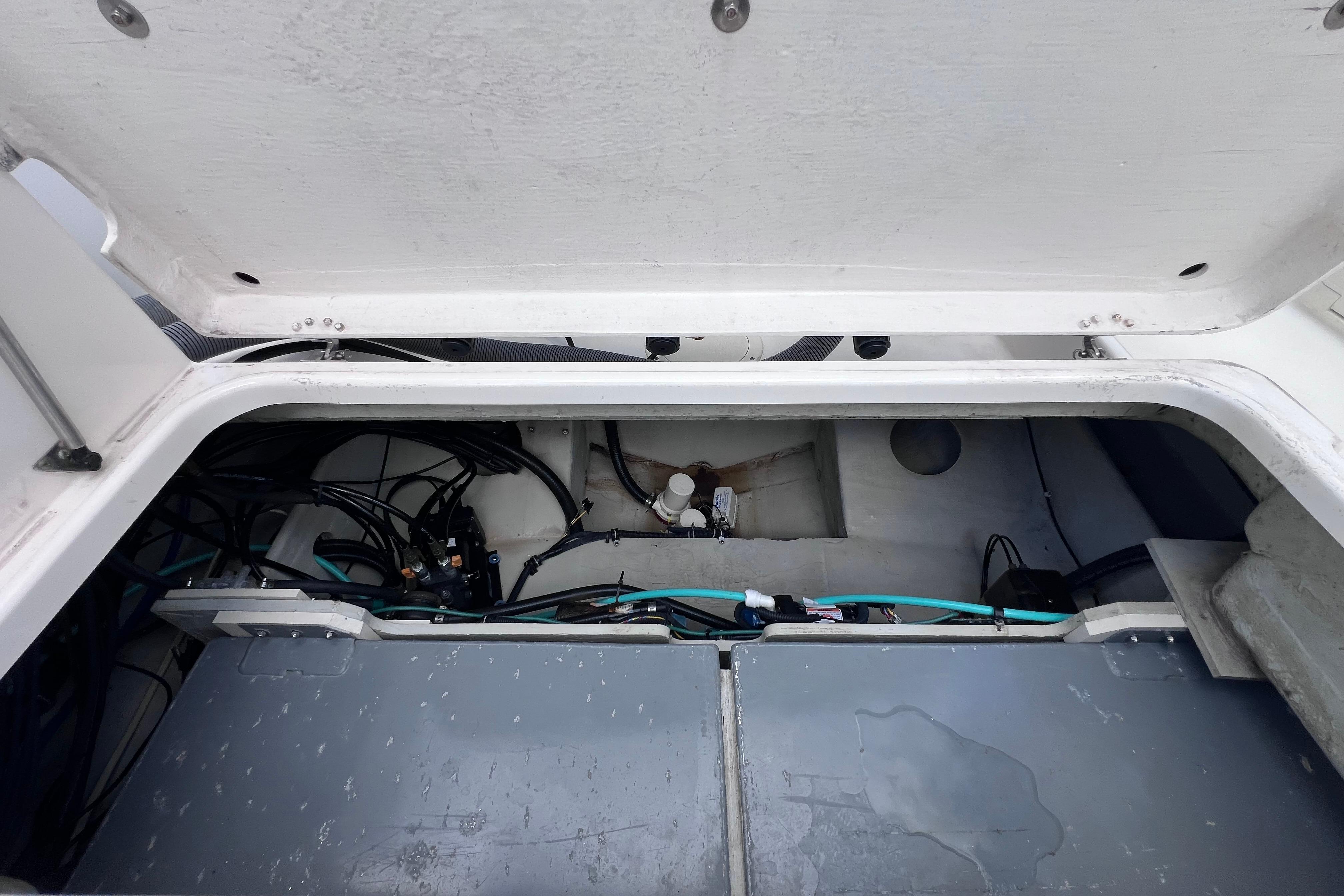 Open hatch of a 2004 Pursuit 2870 Walkaround boat, revealing internal wiring and components.