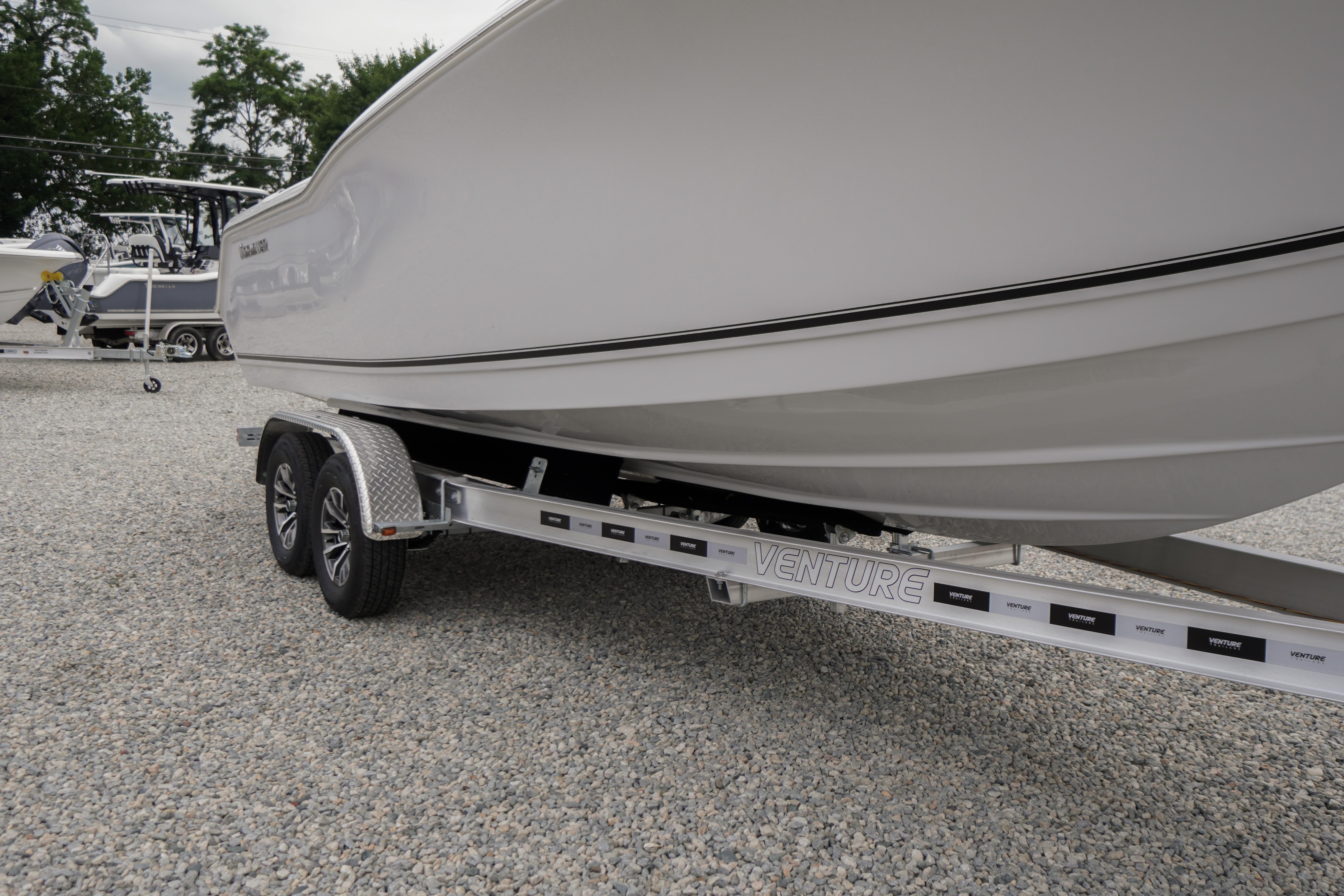 2026 Tidewater 232 SS boat on Venture trailer, parked on gravel lot.