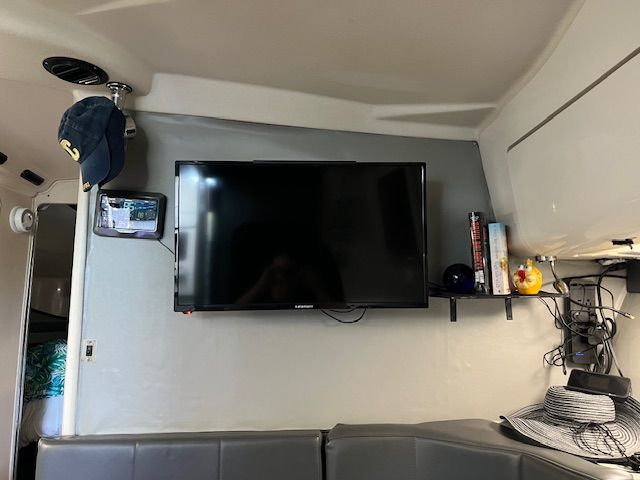 Interior of a 1989 Trojan 370 Express with a TV and shelves.