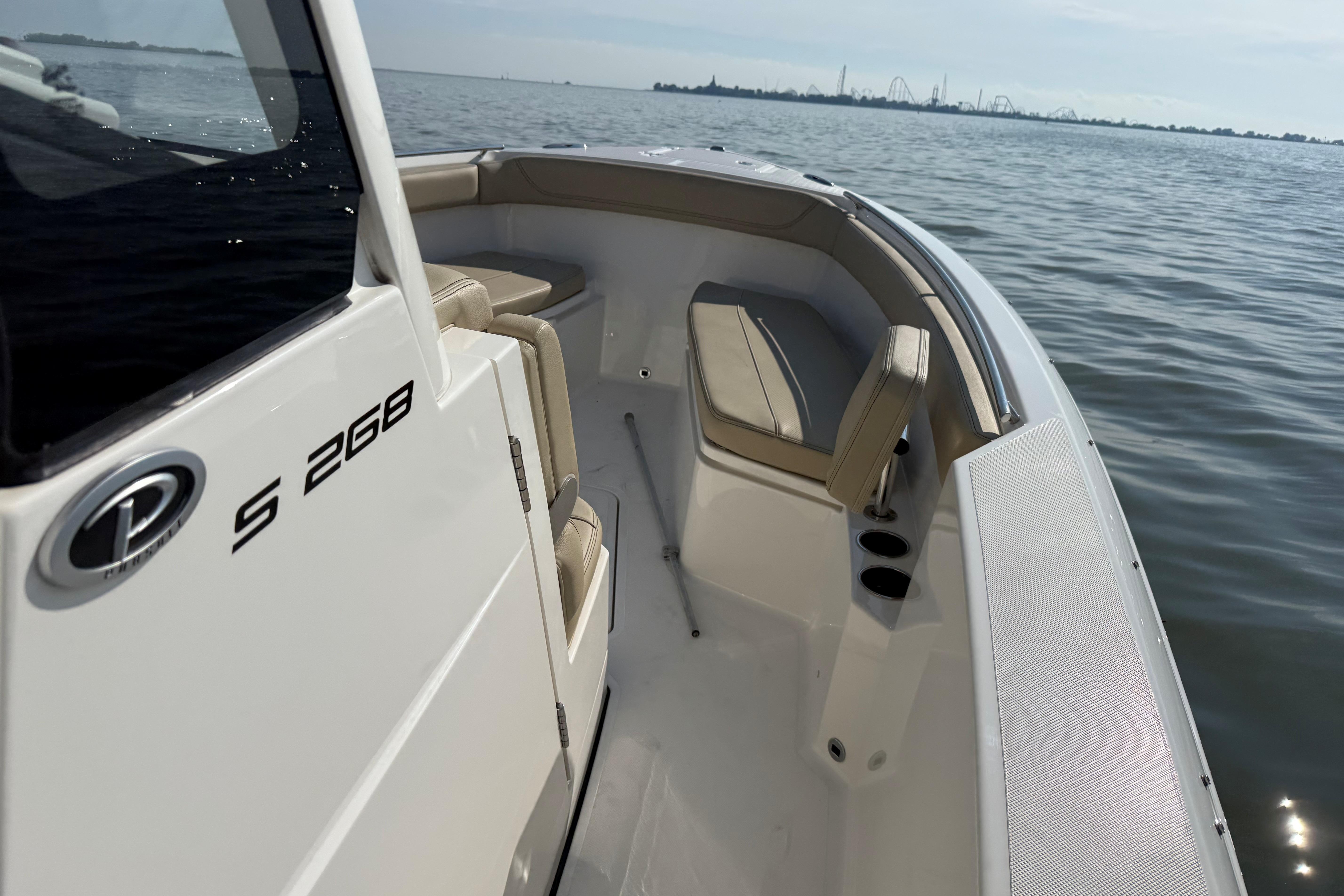 2021 Pursuit S 268 Sport boat on calm water, showcasing seating and sleek design.