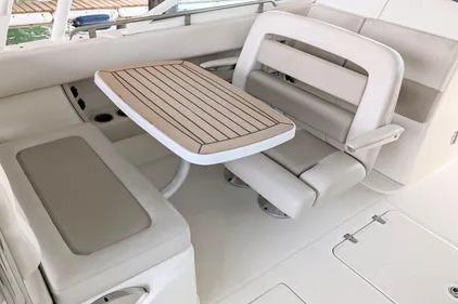 2017 Boston Whaler 320 Vantage interior with cushioned seating and wooden table.