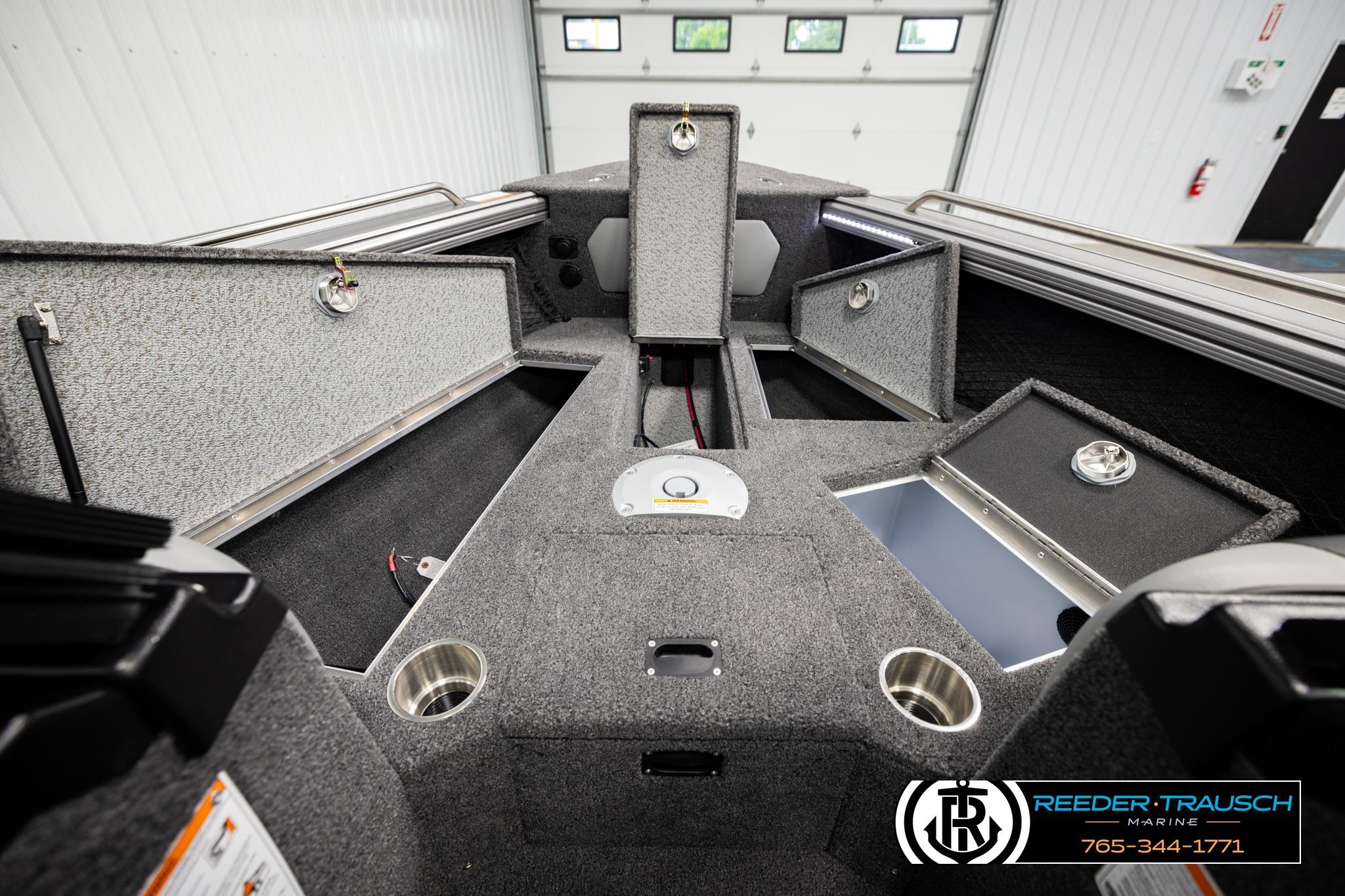 Interior of 2026 Lund 1975 Tyee boat with open storage compartments and cup holders.