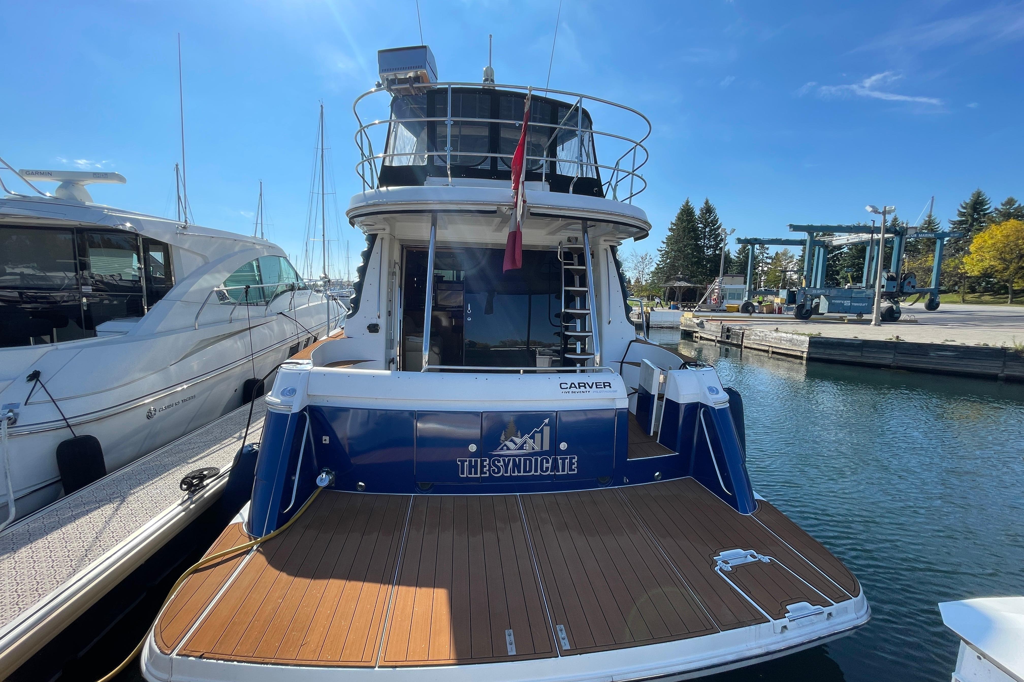 2002 Carver 570 Voyager Pilothouse docked at marina under clear blue sky.