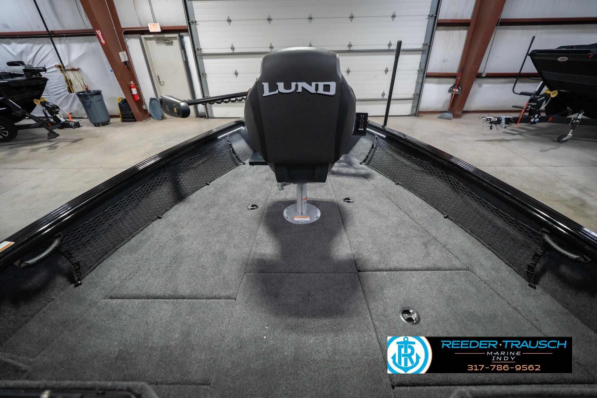2026 Lund 2075 Impact XS boat interior in showroom, featuring spacious deck and seating.