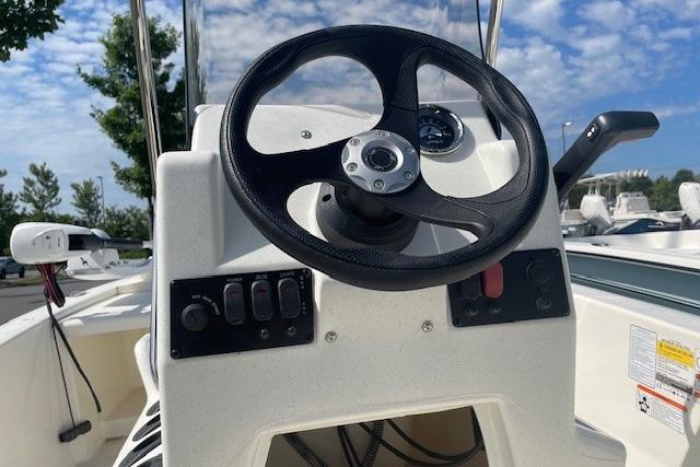 2026 Mako Pro Skiff 13 CC steering console with controls, outdoors under blue sky.