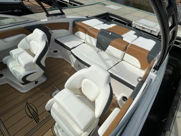2025 Chaparral 21 SSi boat interior with white and brown seating, docked at marina.