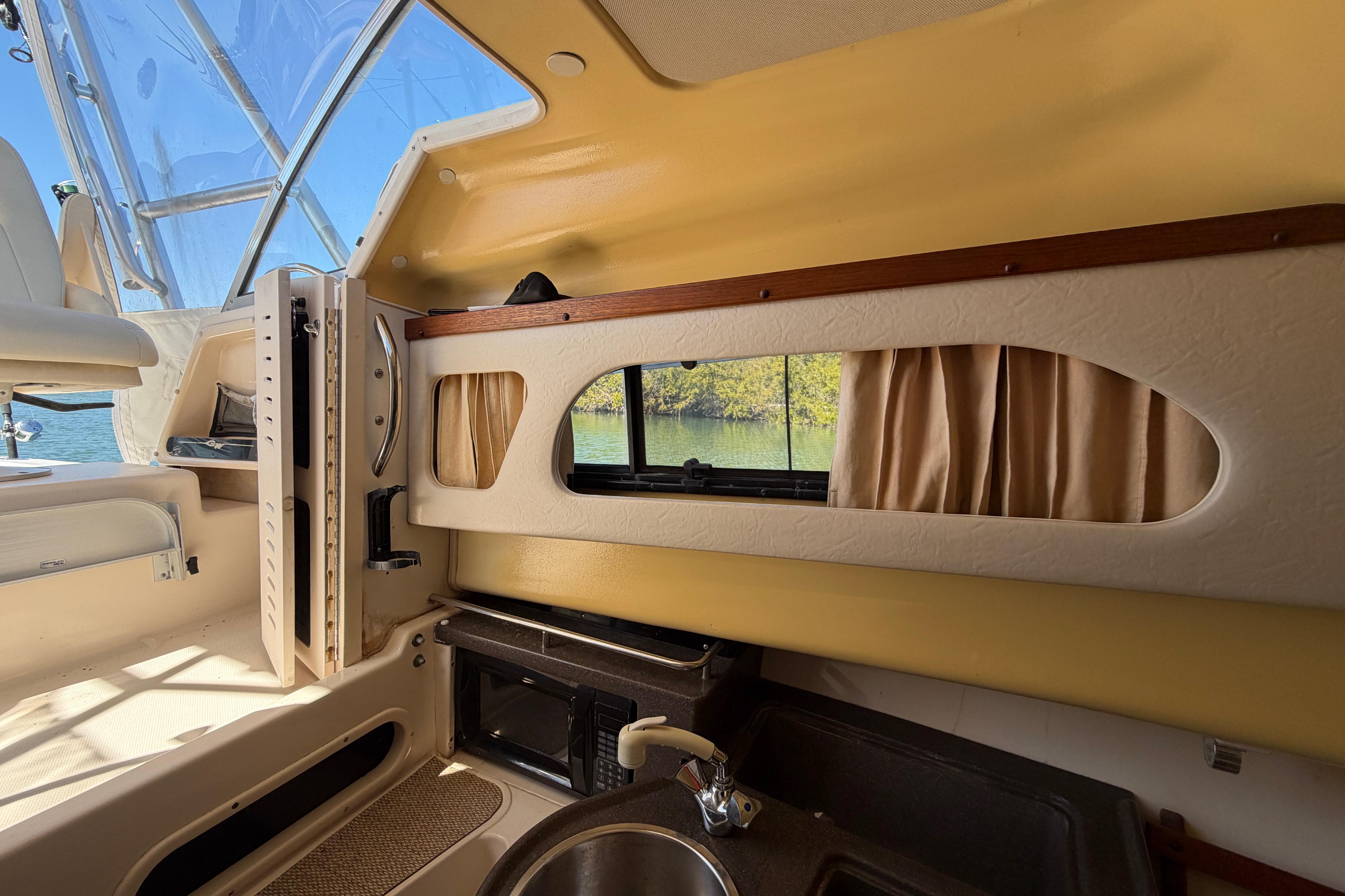 Interior of 2006 Grady-White Sailfish 282 boat, featuring kitchenette and window view.