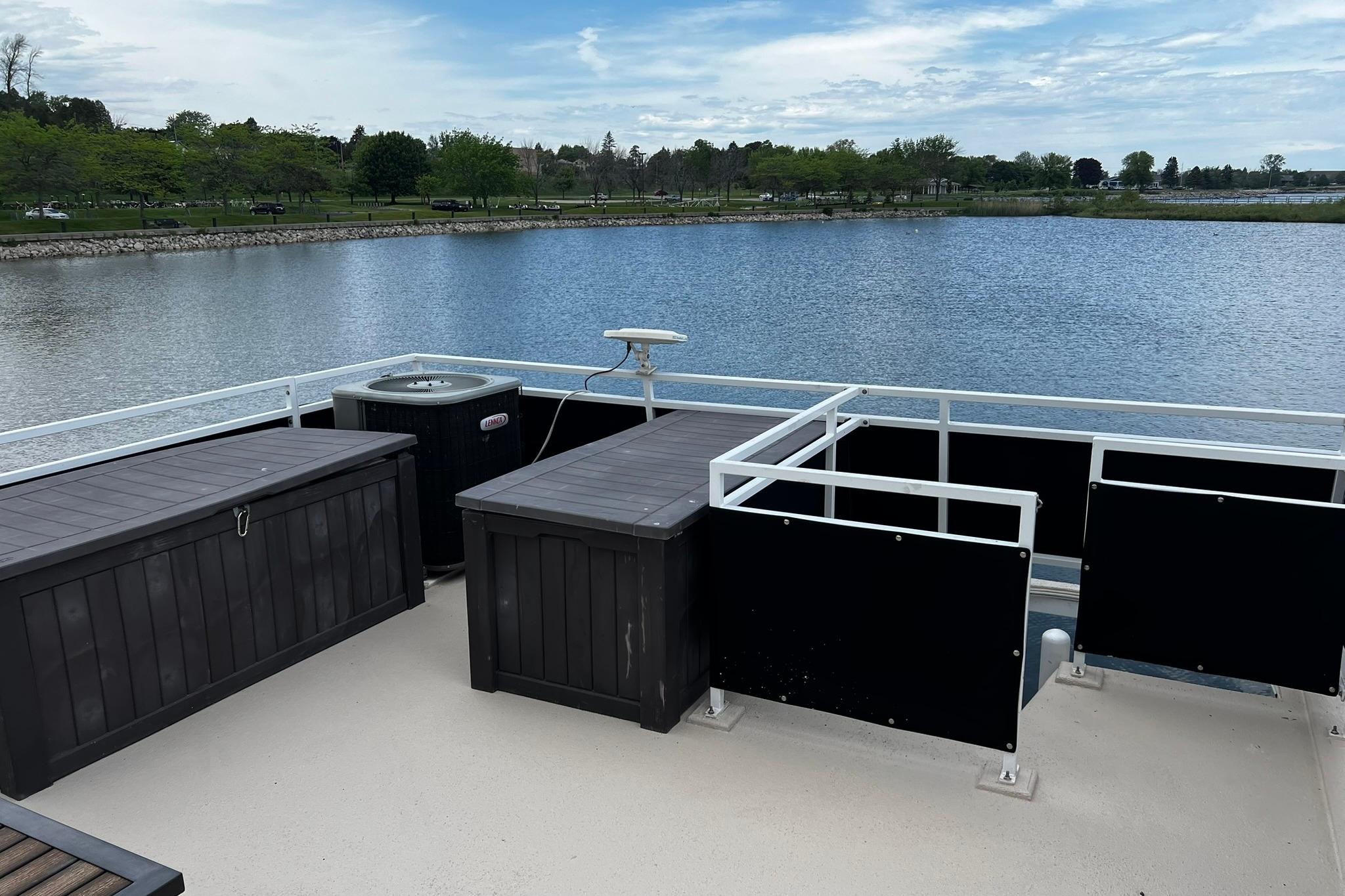 2010 Skipperliner 480 Flybridge deck overlooking serene lake and lush shoreline.