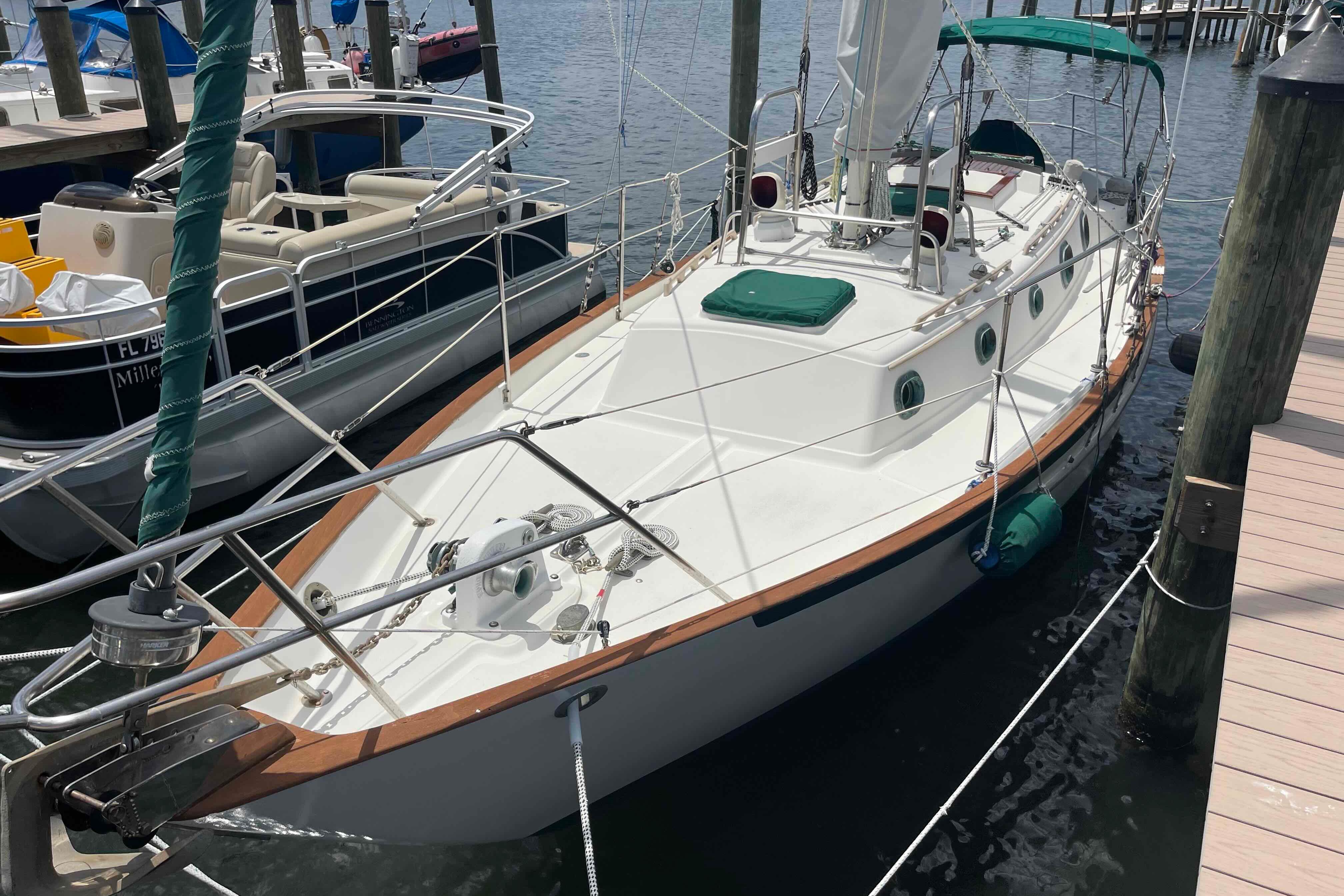 1987 Pacific Seacraft 34 sailboat docked at a marina, featuring a clean white deck.