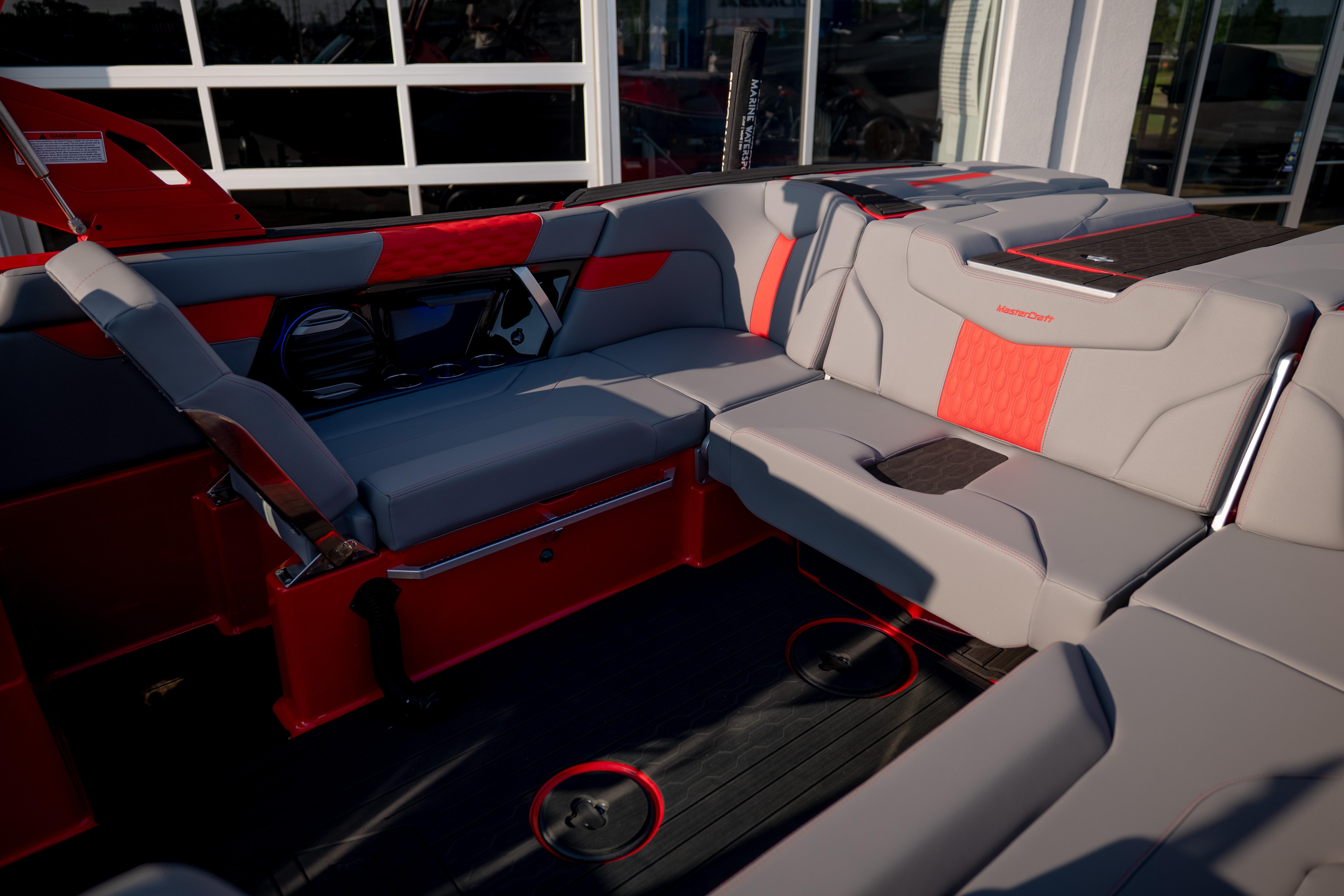 2027 MasterCraft XT24 boat interior with red and gray seating, showcasing modern design.