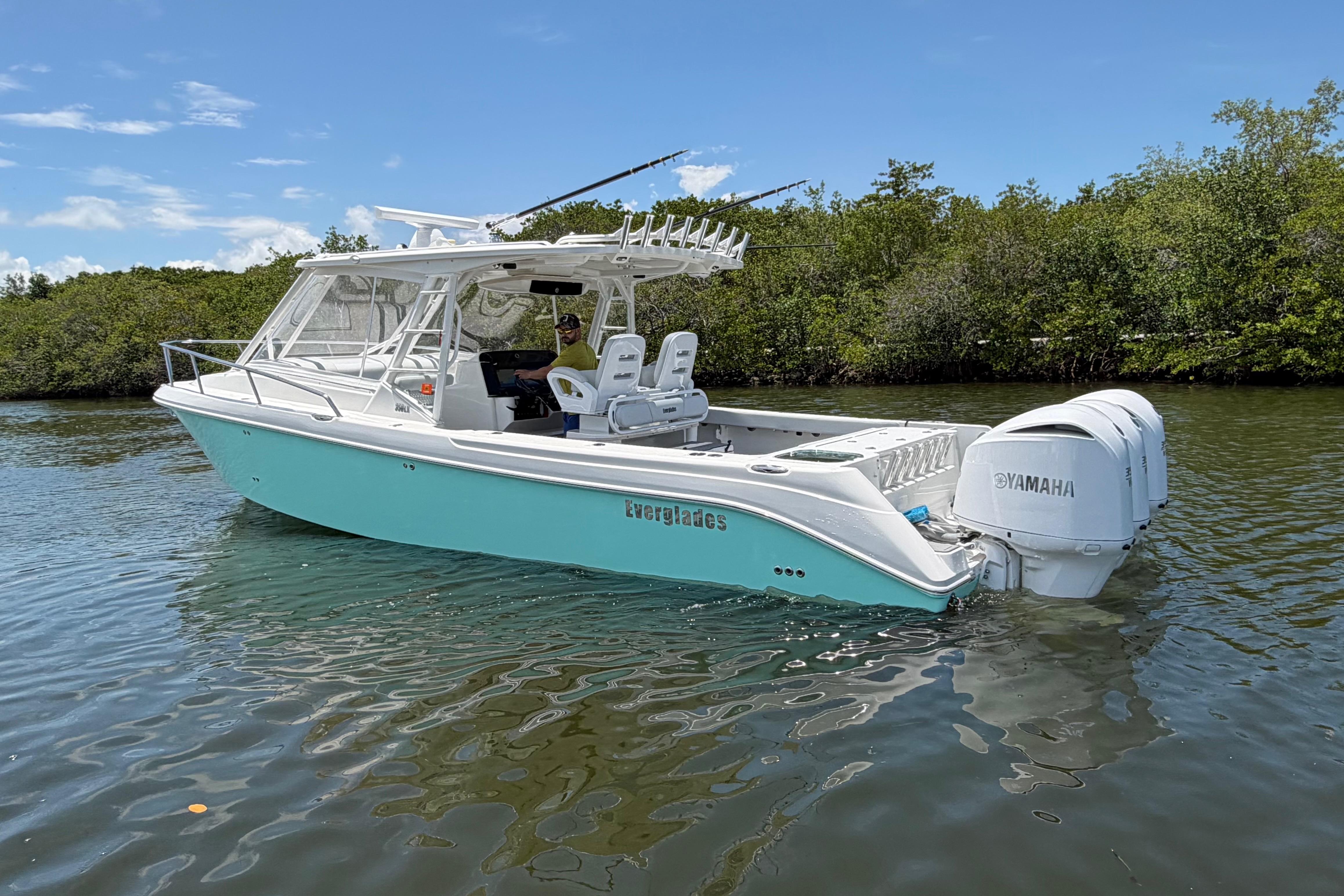 2009 Everglades 350LX boat with Yamaha engines on calm water, surrounded by greenery.