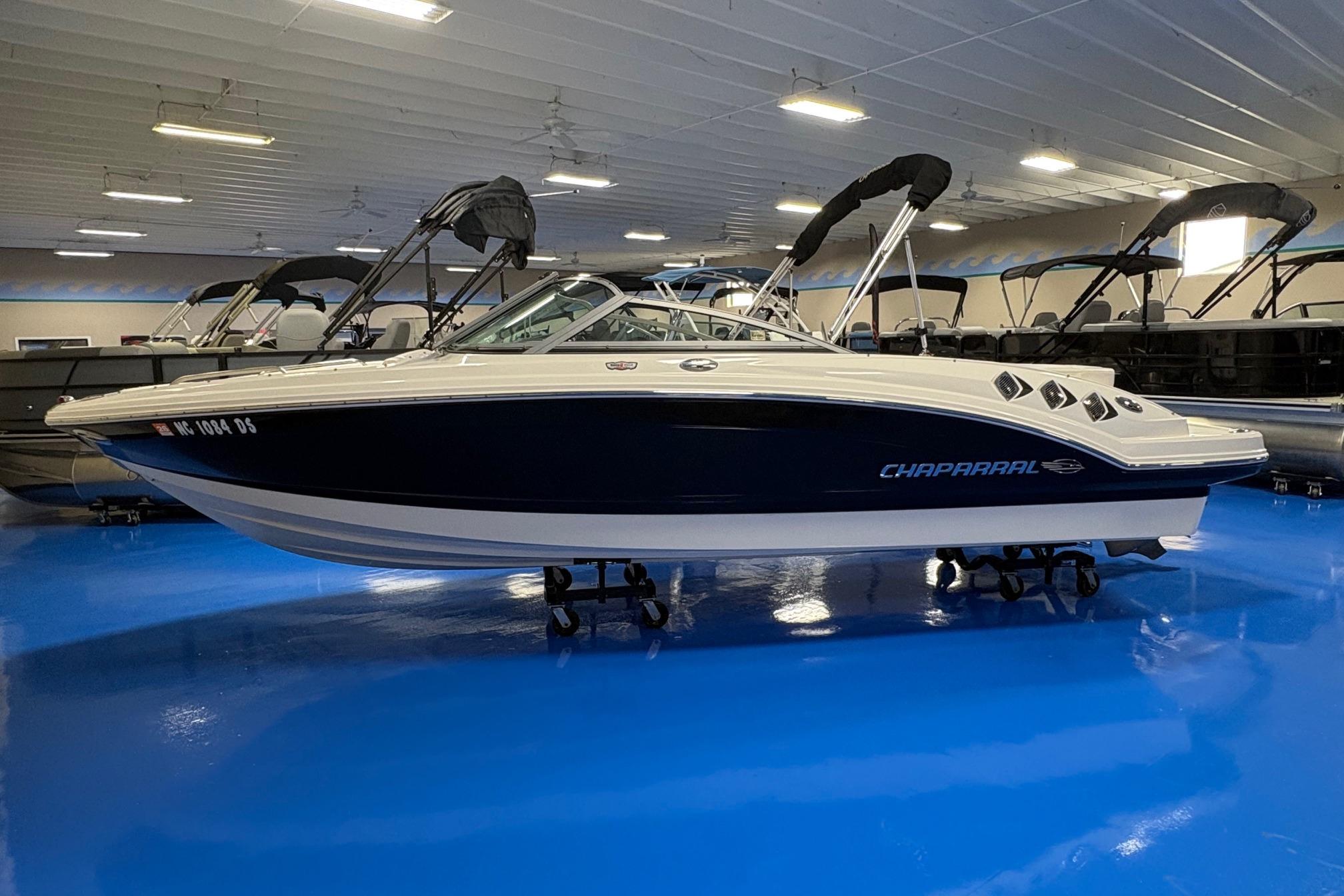 2011 Chaparral 216 SSi boat displayed indoors on a blue floor.
