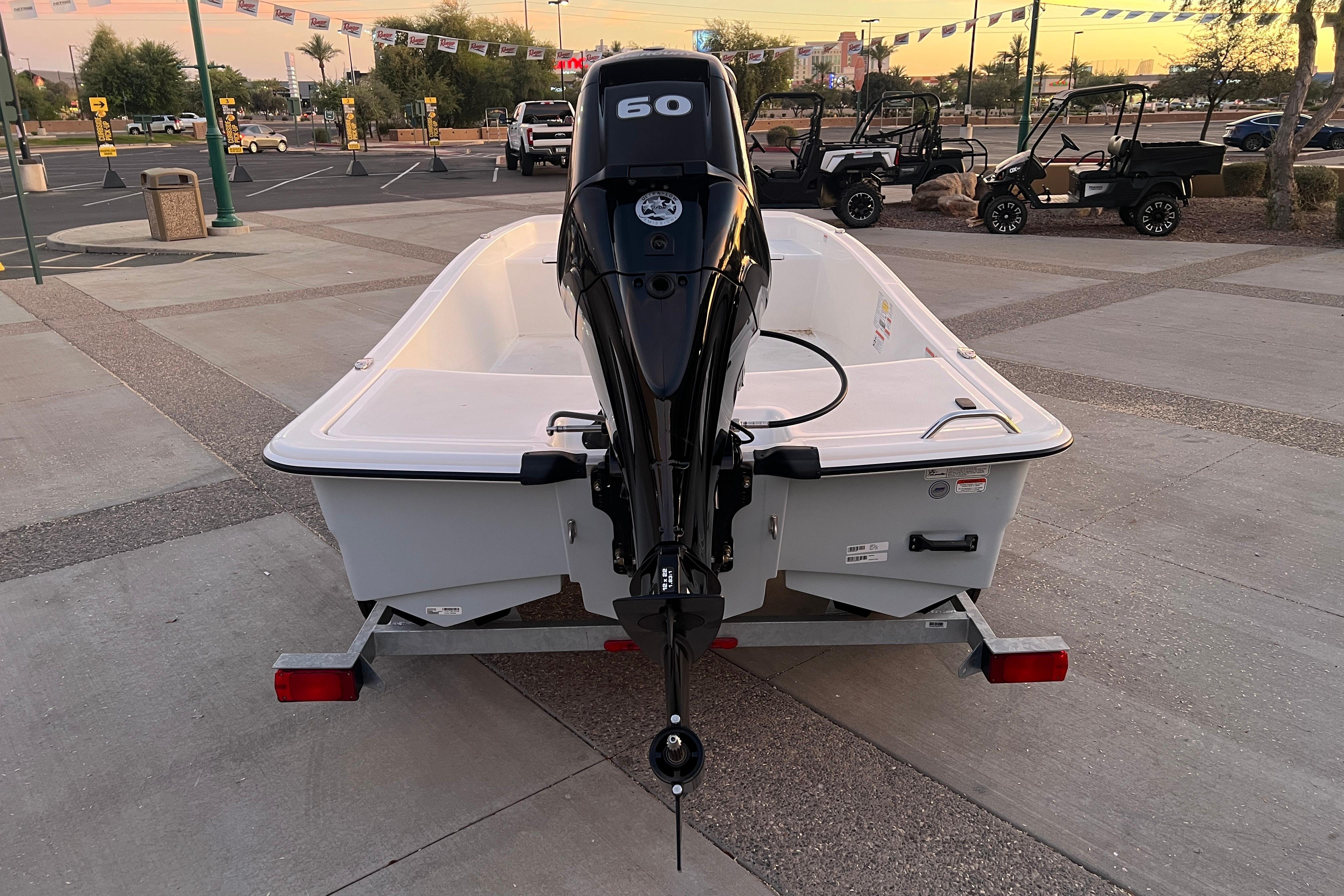 2025 Mako Pro Skiff 15 CC boat on trailer, rear view in parking lot.