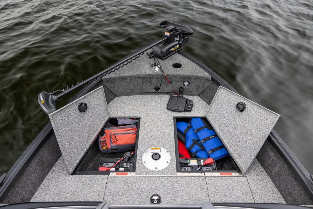 2026 Alumacraft Classic 165 Tiller boat with open storage compartments and safety gear on water.
