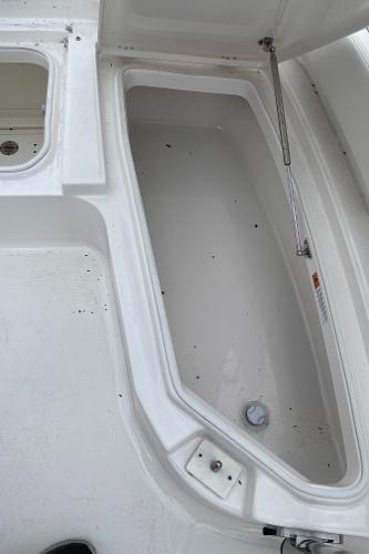 2026 Robalo 246 Cayman storage compartment with open lid, showcasing spacious interior design.