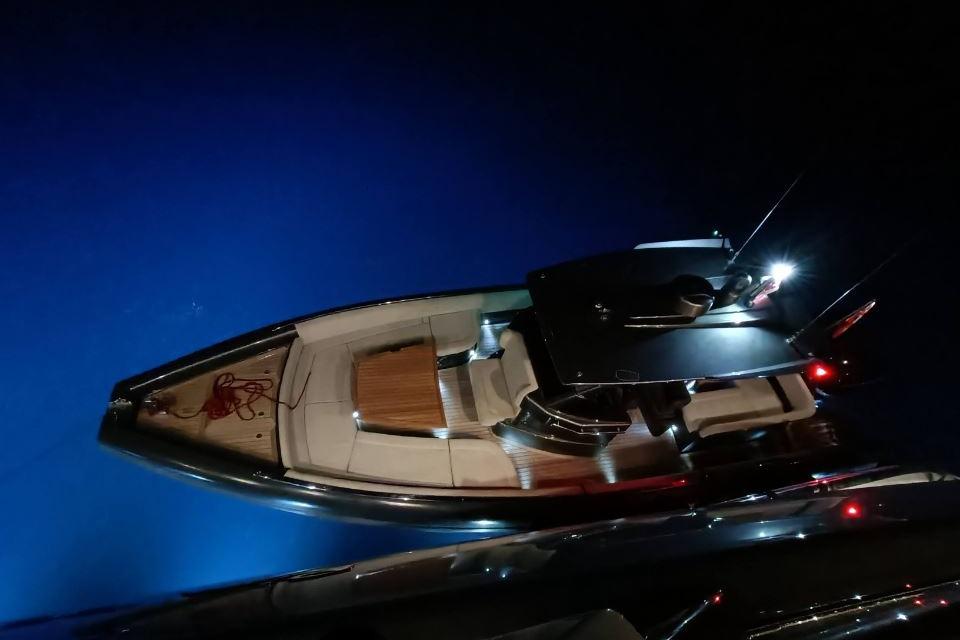 Novamarine Black Shiver 100 yacht, 2021 model, illuminated at night on blue water.