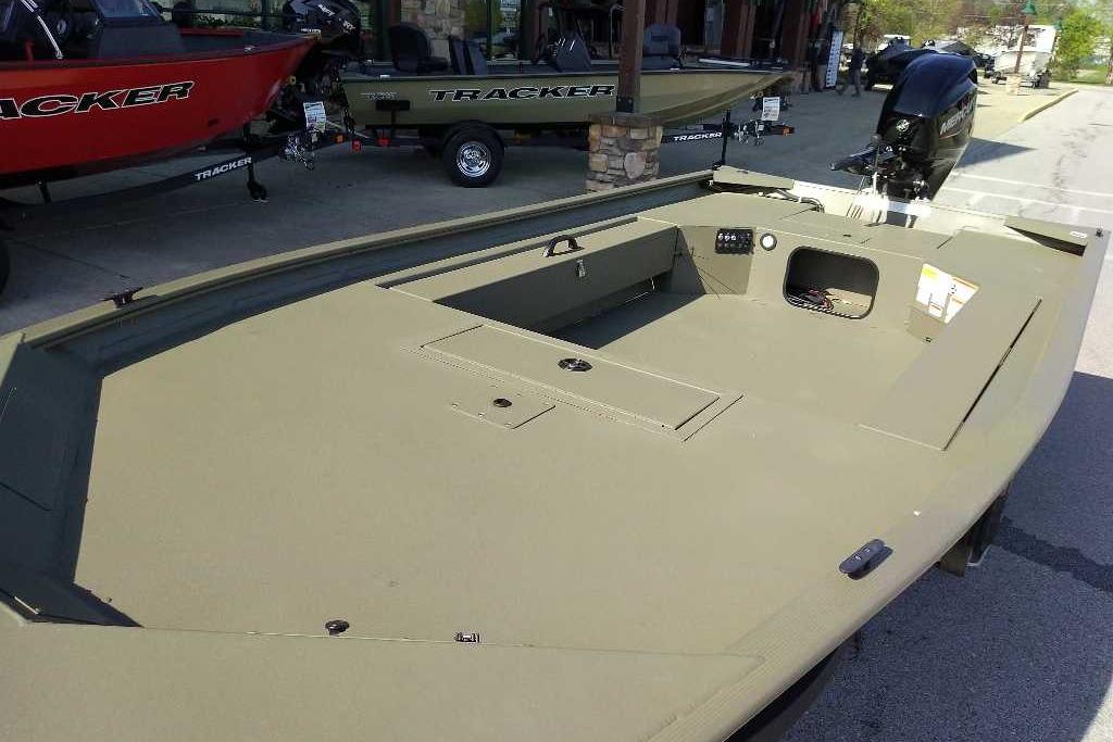 2026 Tracker Grizzly 1654 T Sportsman boat, spacious deck, parked outdoors.