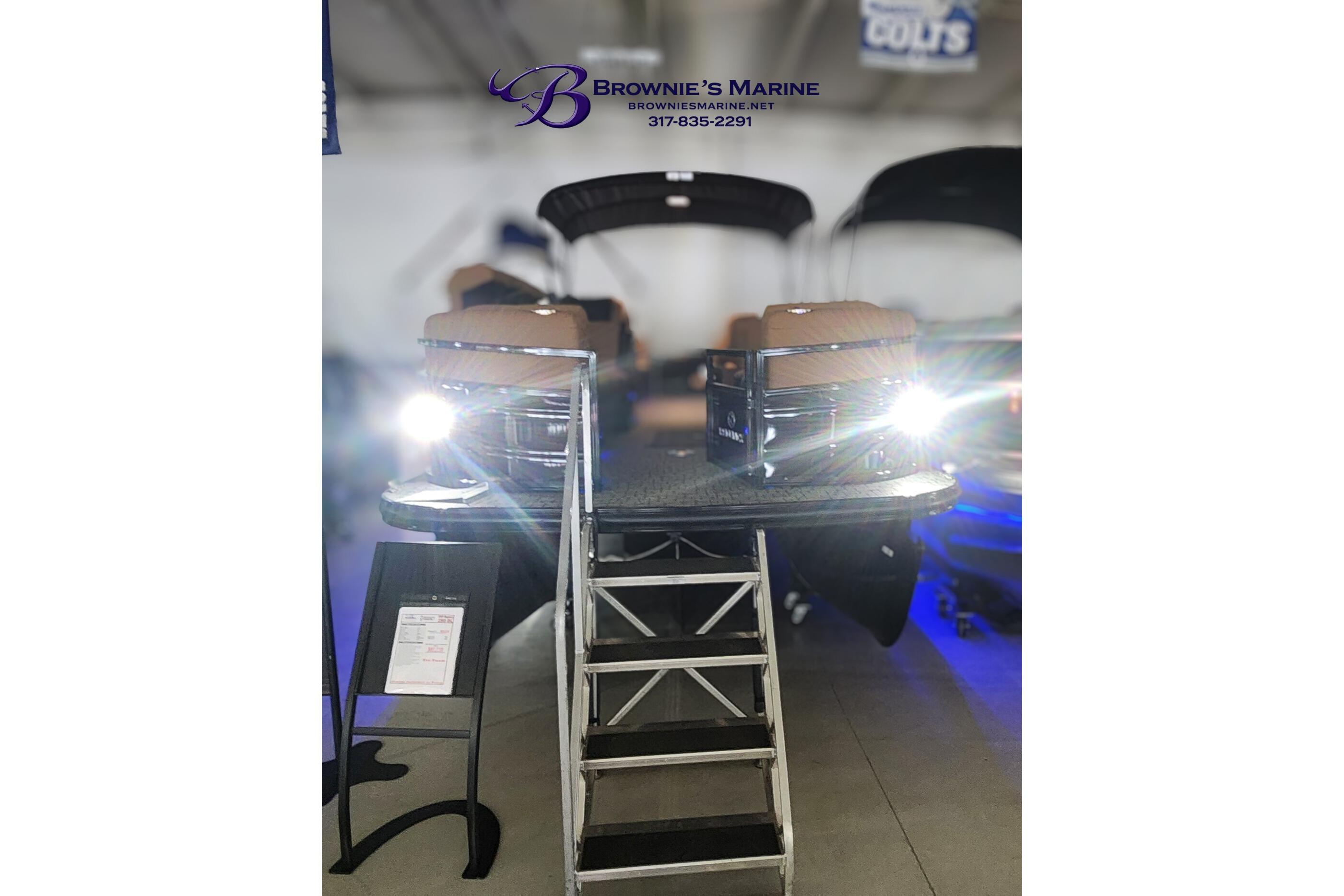 2026 Regency 250 DL boat displayed at Brownie's Marine showroom with bright headlights.