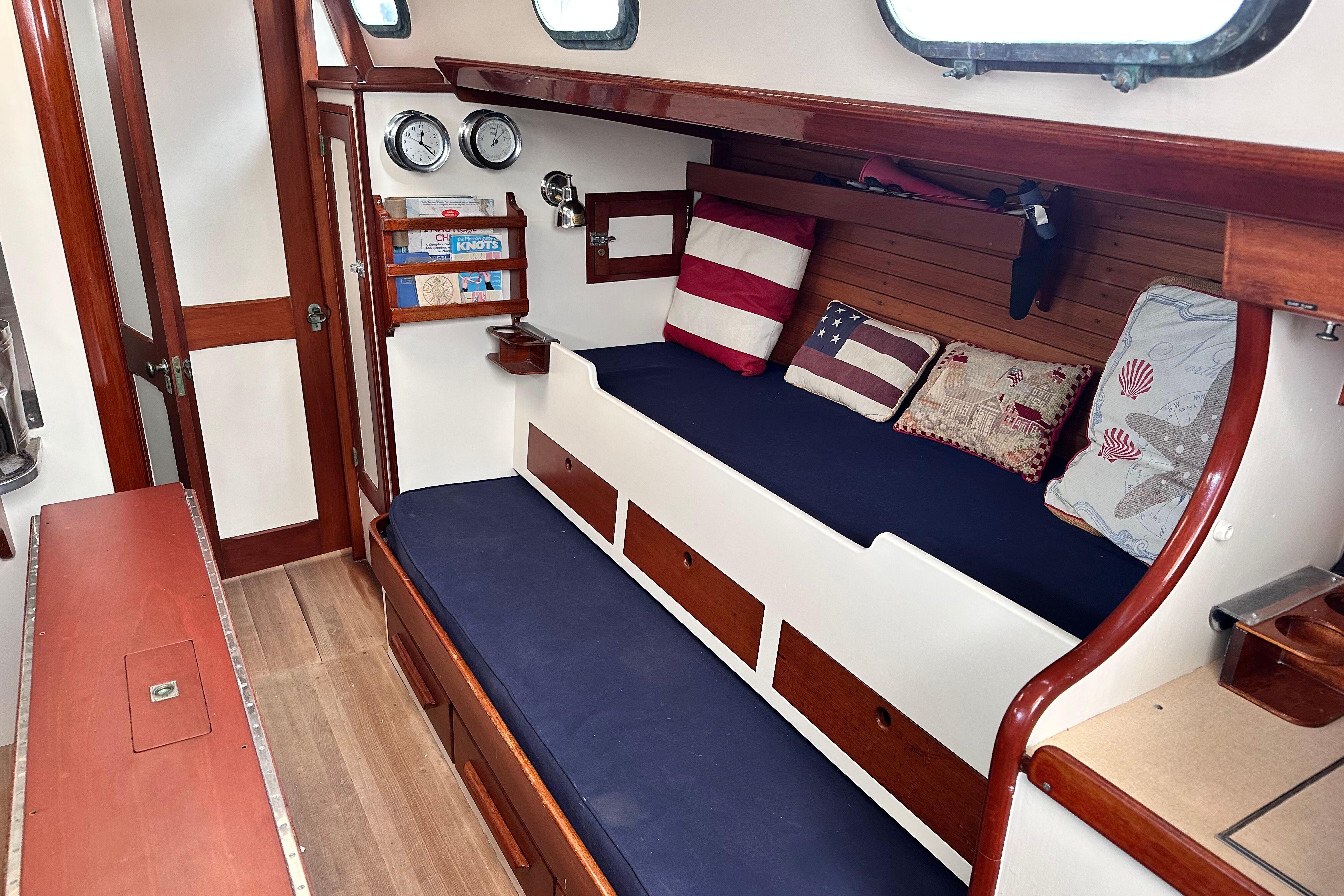 Interior of a 1962 Hinckley Bermuda 40 sailboat with cozy seating and nautical decor.