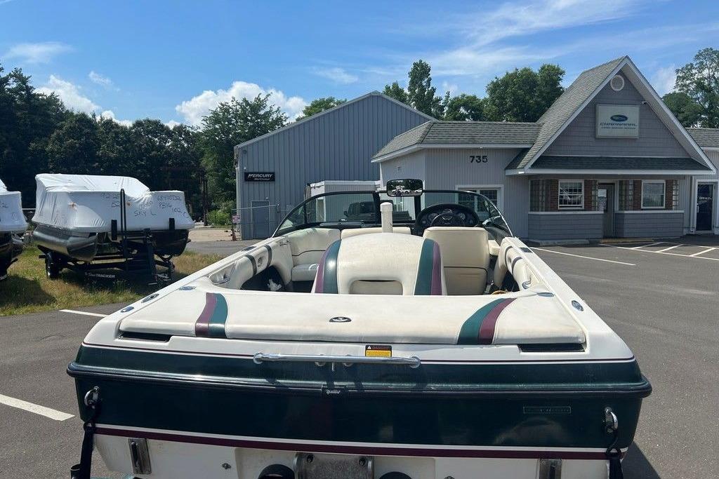 1999 Malibu Response boat parked outside a dealership on a sunny day.