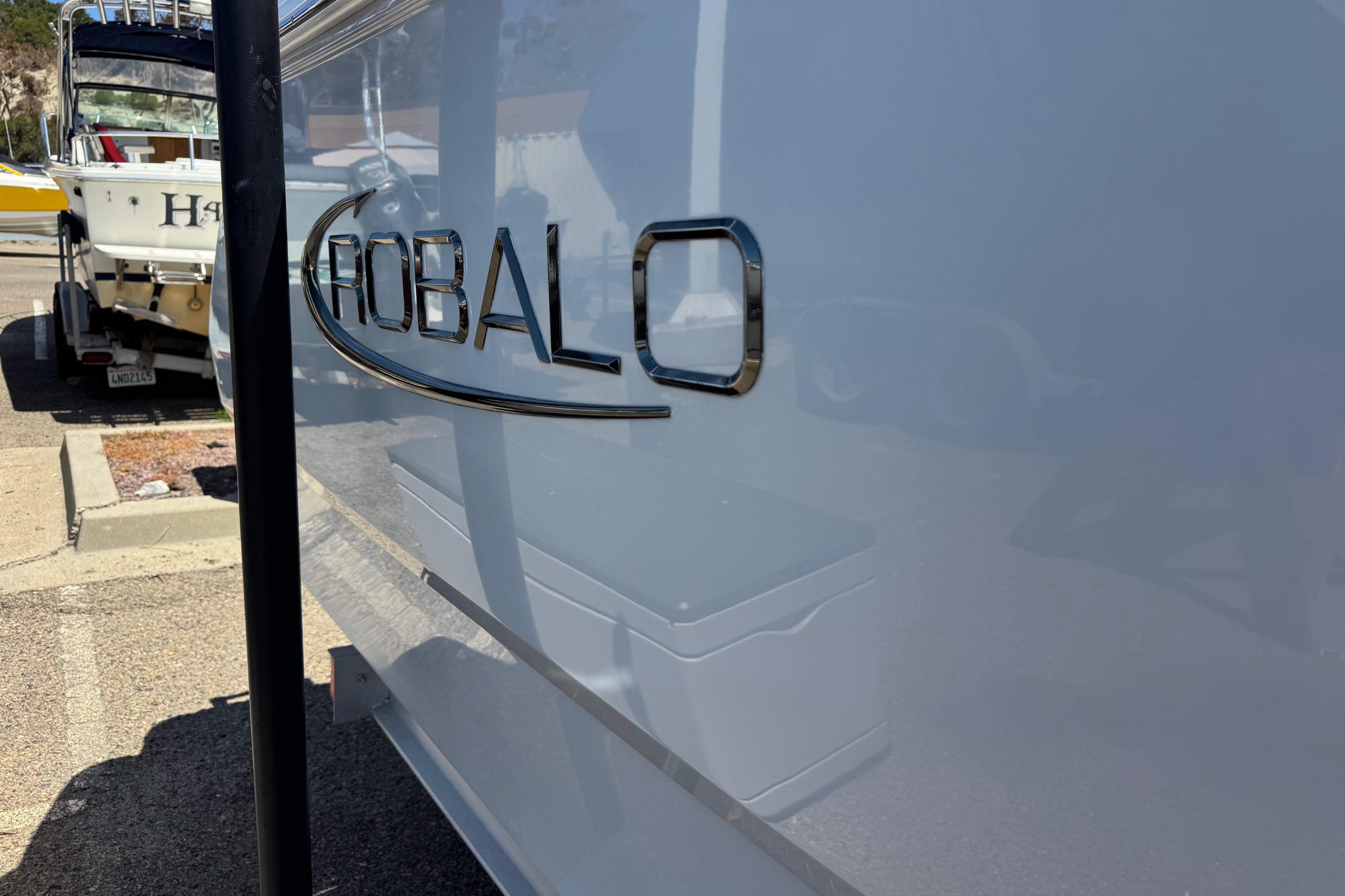 2022 Robalo R230 Center Console boat parked, showcasing sleek design and logo.