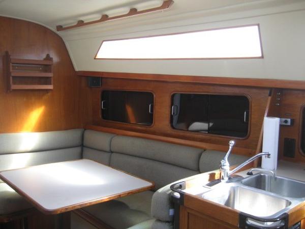 Interior of a 1984 C&C Landfall yacht with seating area and sink.