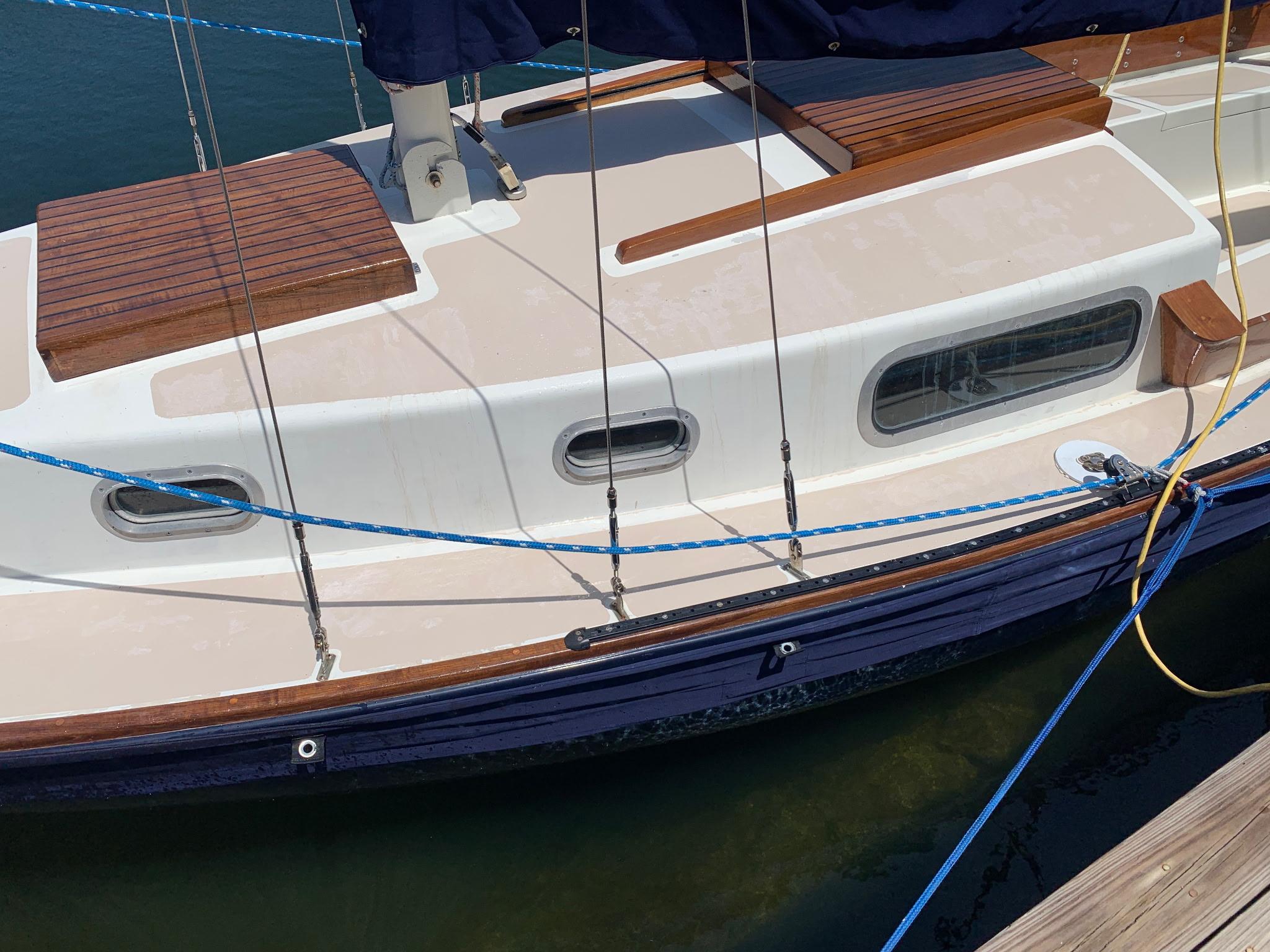 1968 Sailboat 24 docked, featuring wooden deck and blue hull.