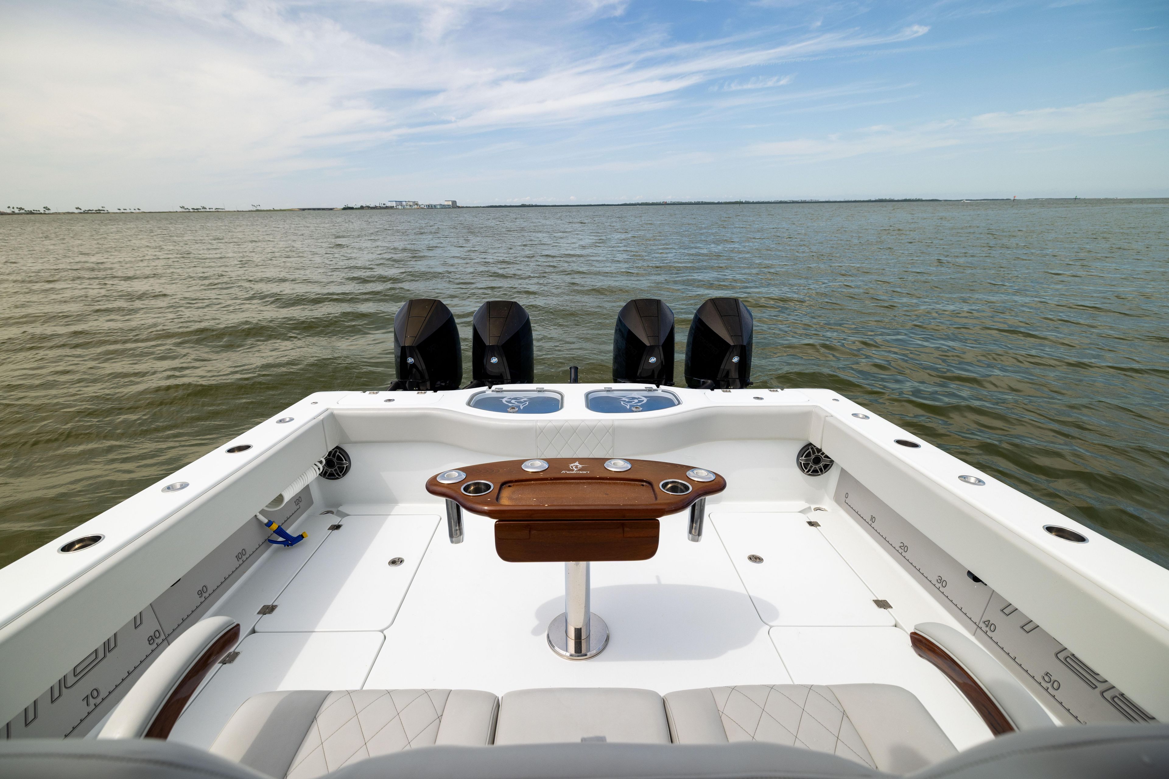 2025 Freeman 42 LR boat with quad engines on open water, featuring a spacious deck.