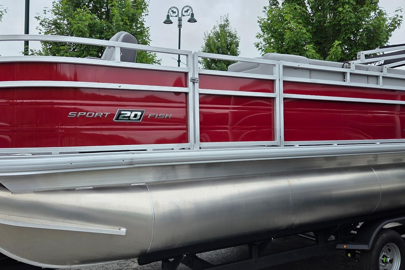 2026 Sun Tracker SportFish 20 DLX pontoon boat with red exterior and silver railing.