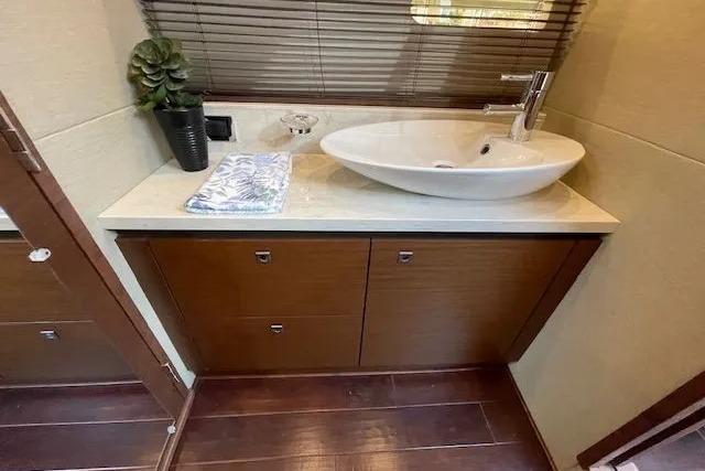 Luxurious bathroom in 2016 Sea Ray Sundancer 510 yacht with modern sink and wooden cabinetry.