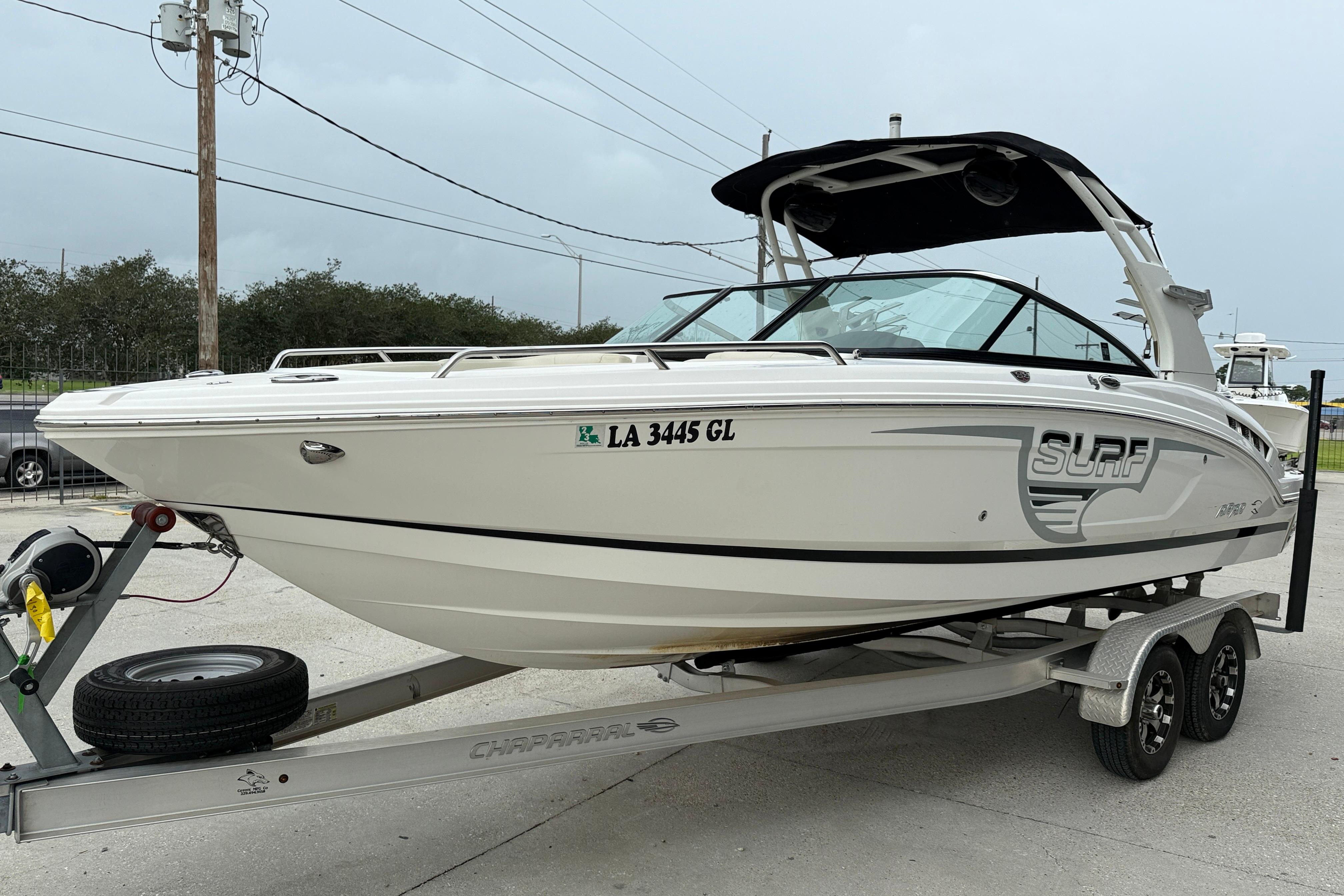 2018 Chaparral 227 SSX Surf boat on trailer, parked outdoors.