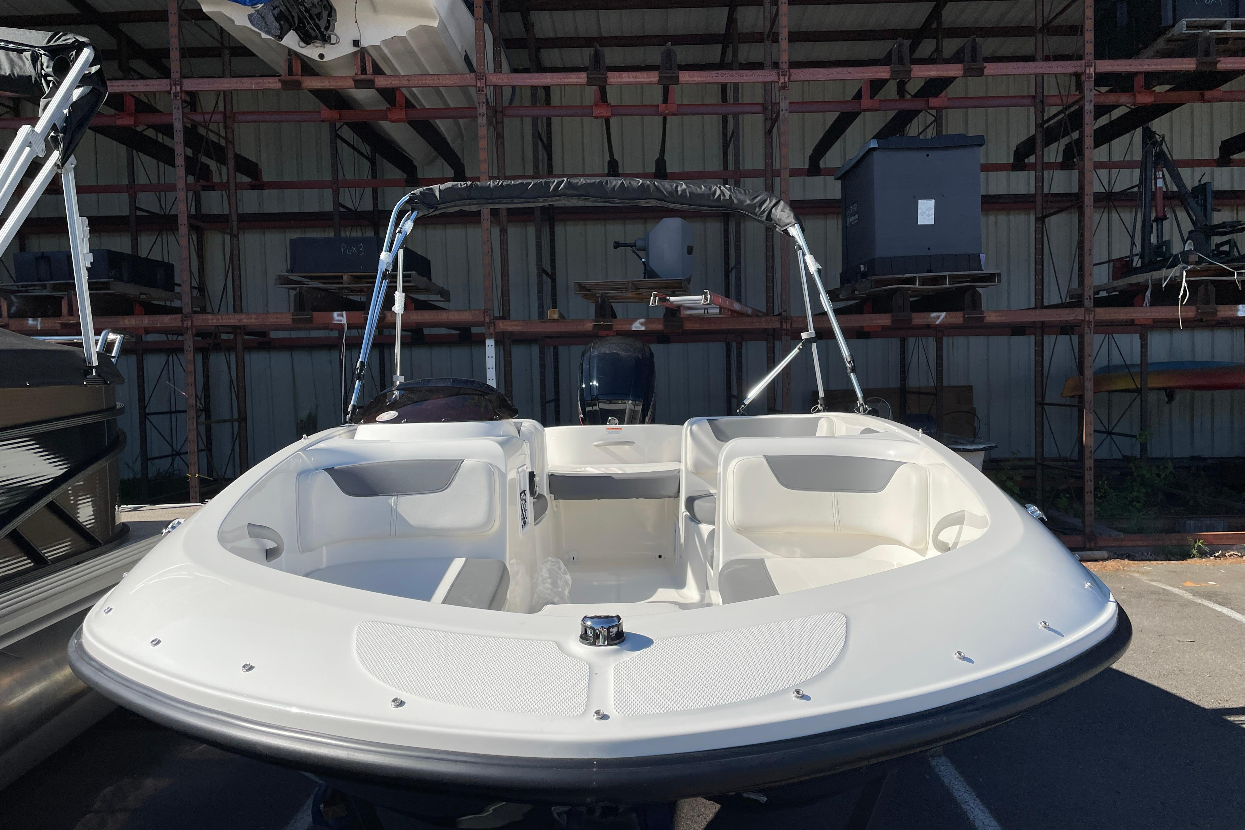 2026 Bayliner Element E16 boat in storage, showcasing sleek design and spacious seating.