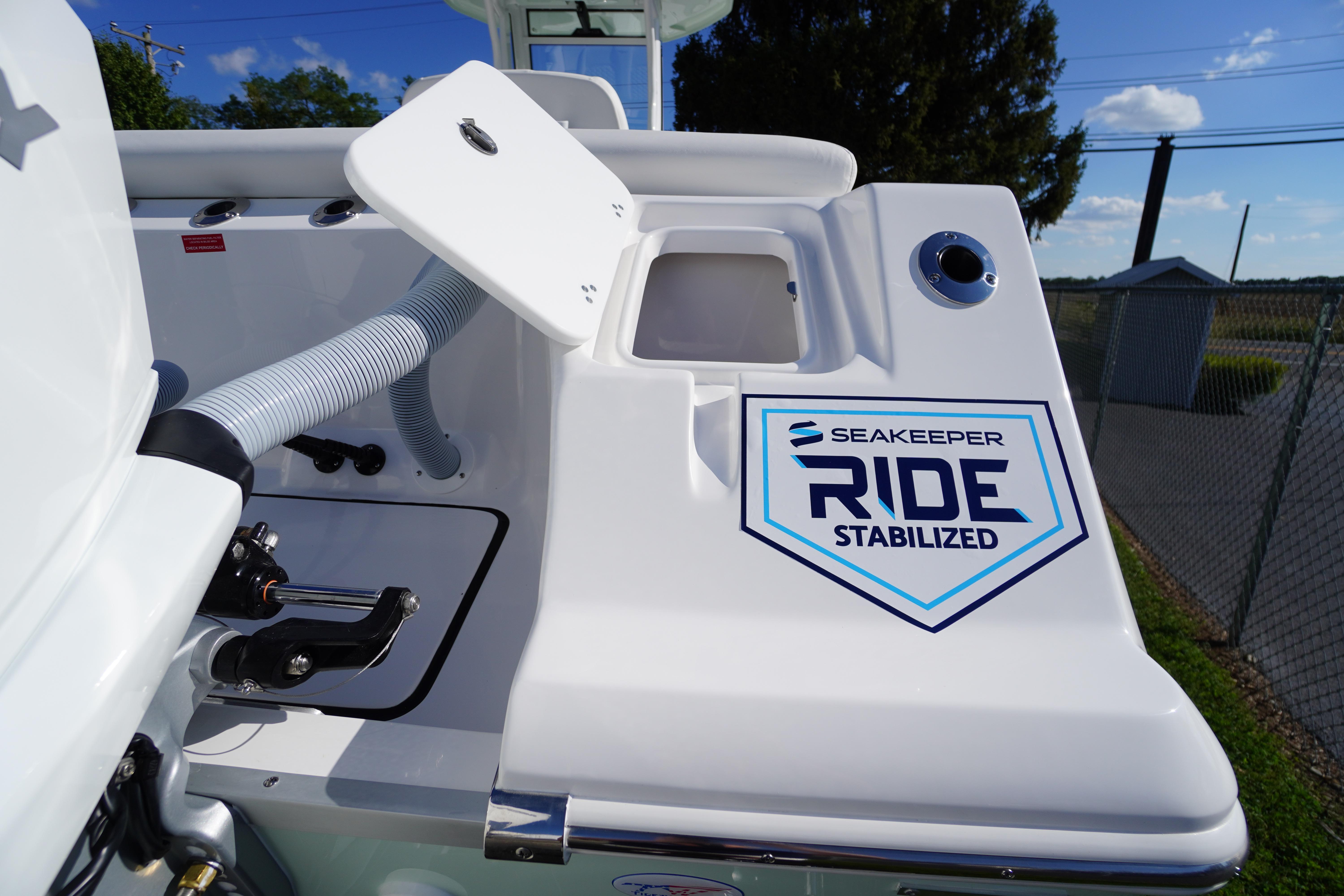 2026 Tidewater 272 LXF boat with Seakeeper Ride stabilization system, open compartment, sunny day.