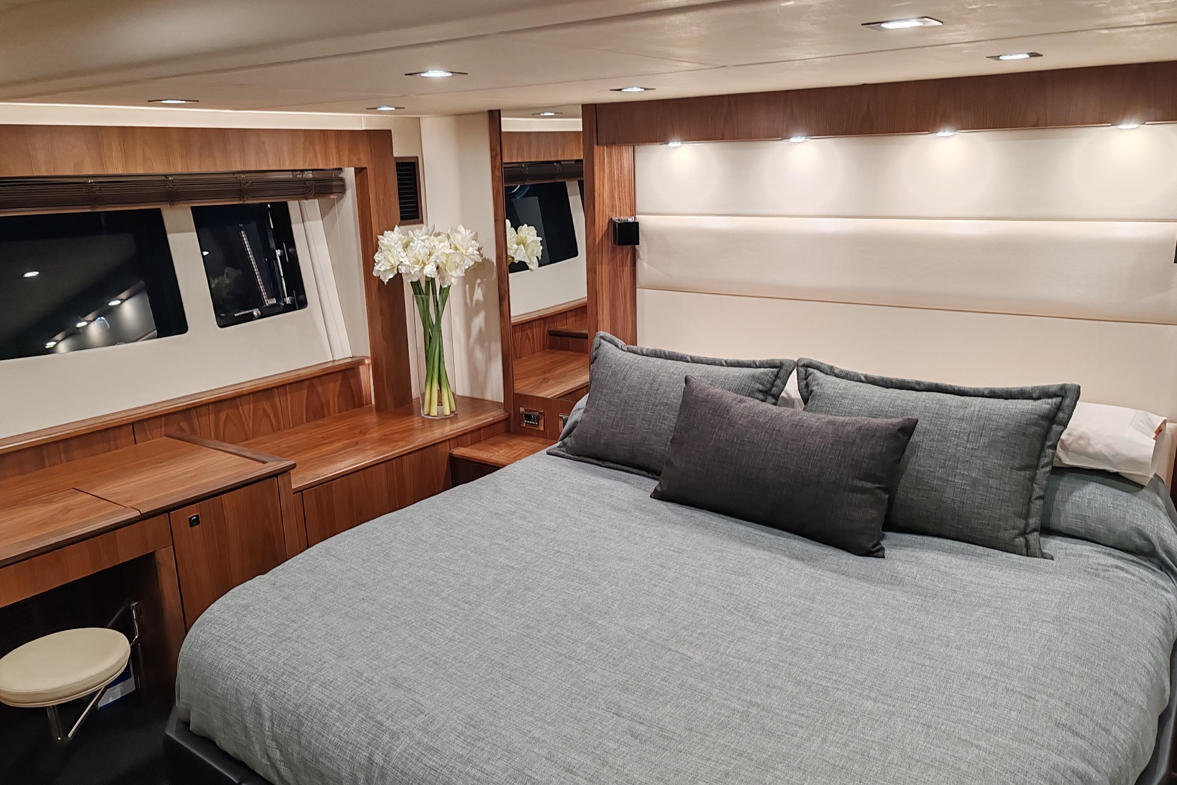 Luxurious bedroom interior of 2010 Sunseeker Predator 64 yacht with elegant wood finish.