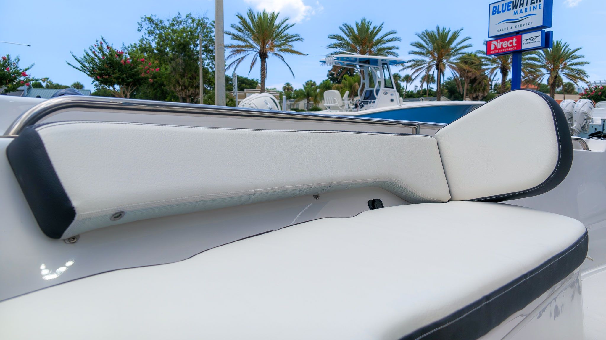 Seating area on a boat with white upholstery and black trim.