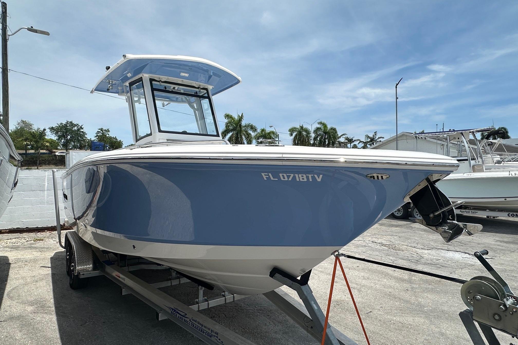 2024 Robalo R250 Center Console boat on trailer, parked outdoors.