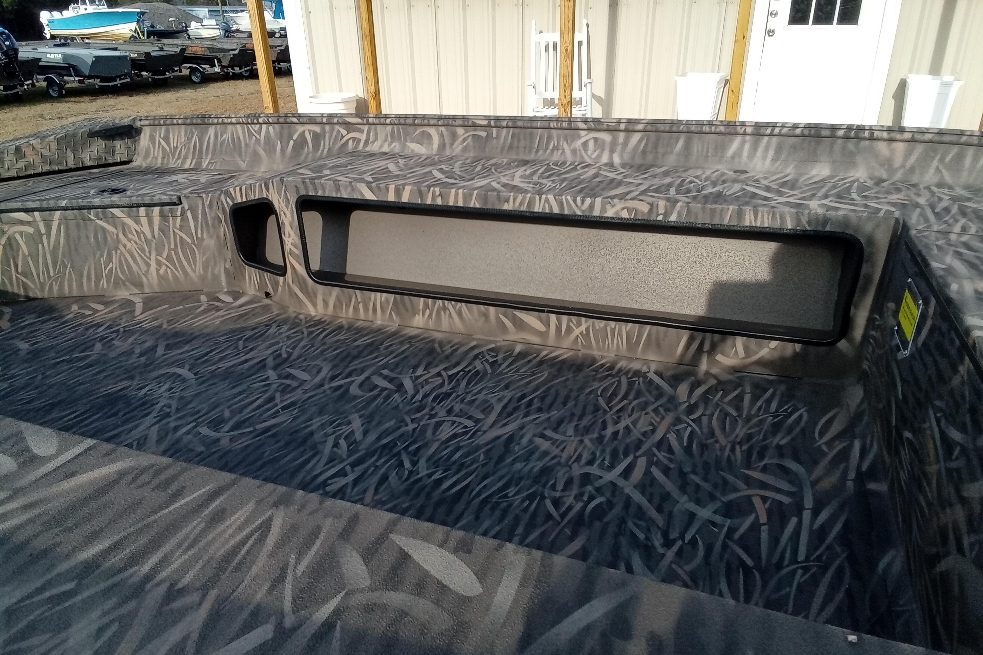 2026 Alweld 1756 Invader boat interior with camouflage pattern and storage compartments.