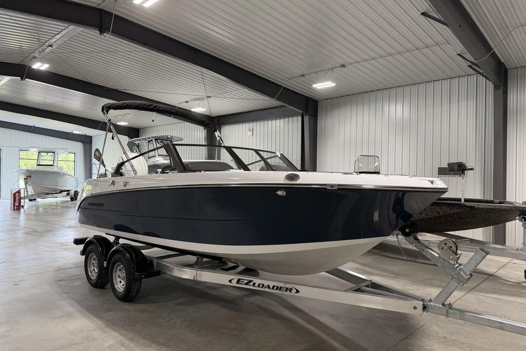 2027 Stingray 20 SBX boat on trailer in indoor showroom.