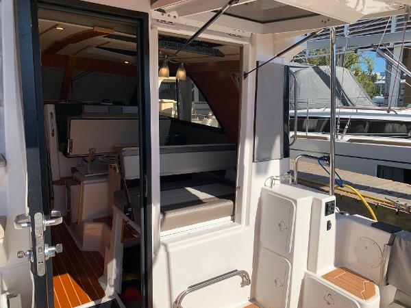 2021 Cutwater C-32 CB boat interior with seating and wooden flooring.