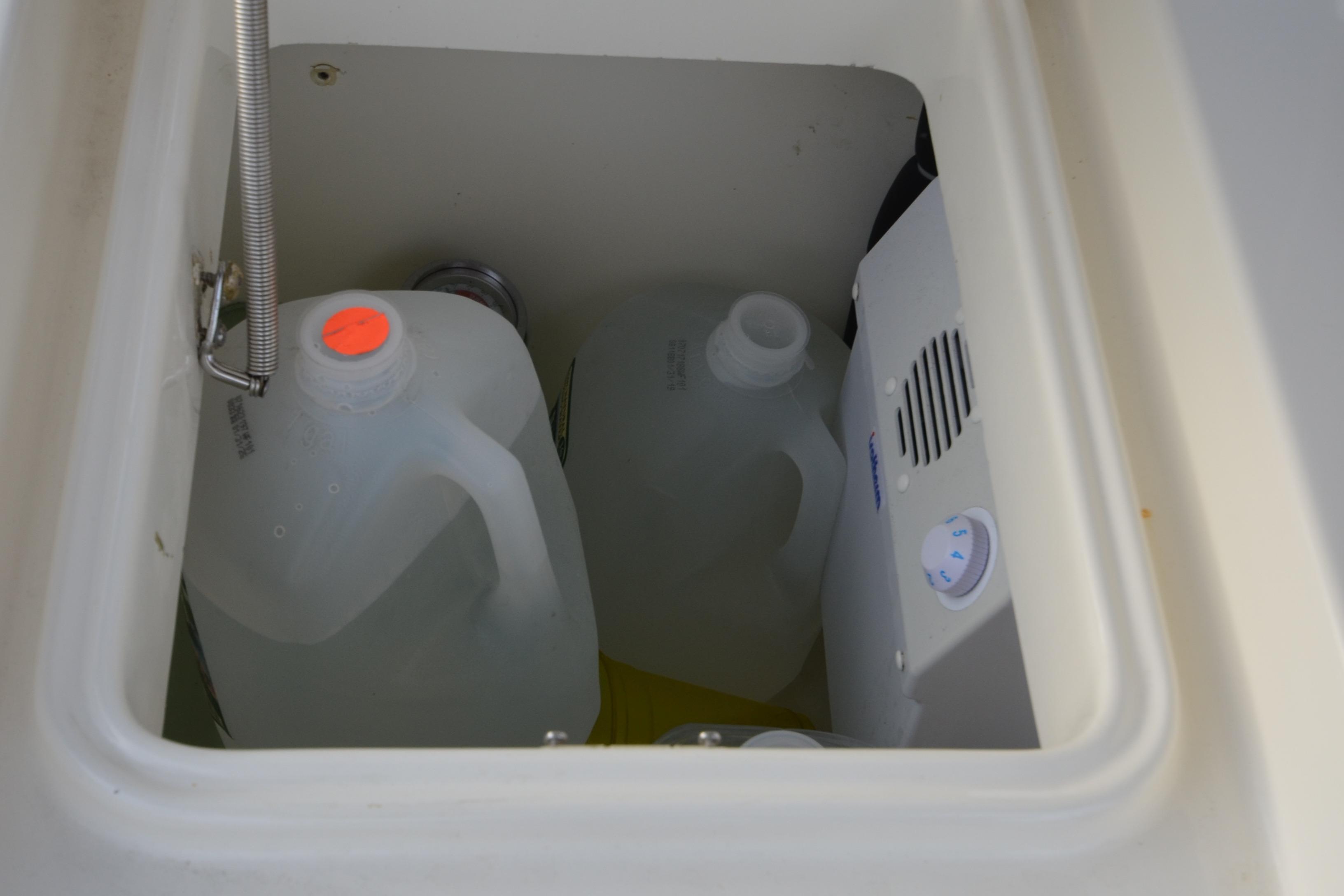 Storage compartment on a 2007 Jeanneau Prestige 46 yacht with water jugs and equipment.