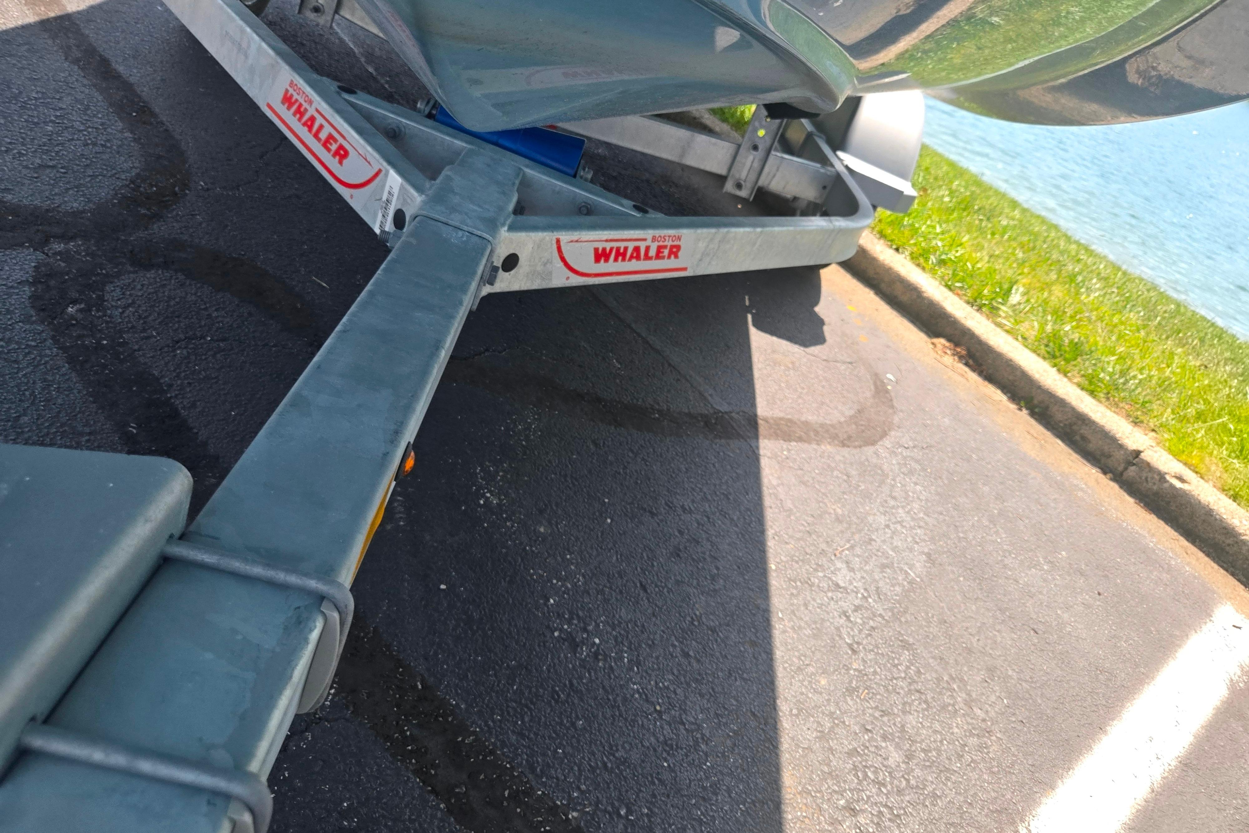 Trailer for 2025 Boston Whaler 130 Super Sport near a lakeside.