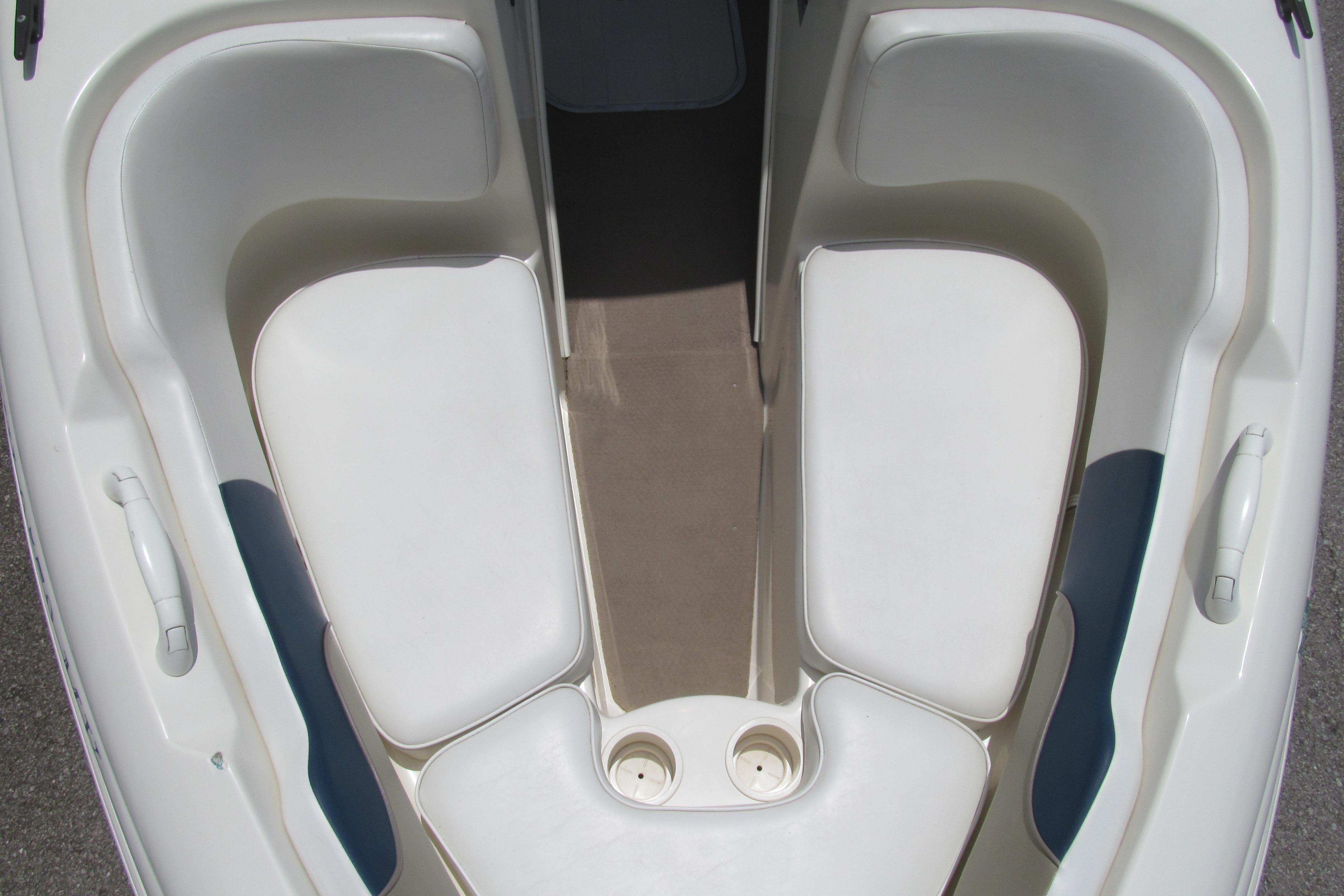 2000 Rinker boat interior with white cushioned seating and cup holders.