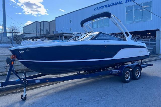 2025 Cobalt CS23 Surf boat on trailer, parked outdoors near industrial building.