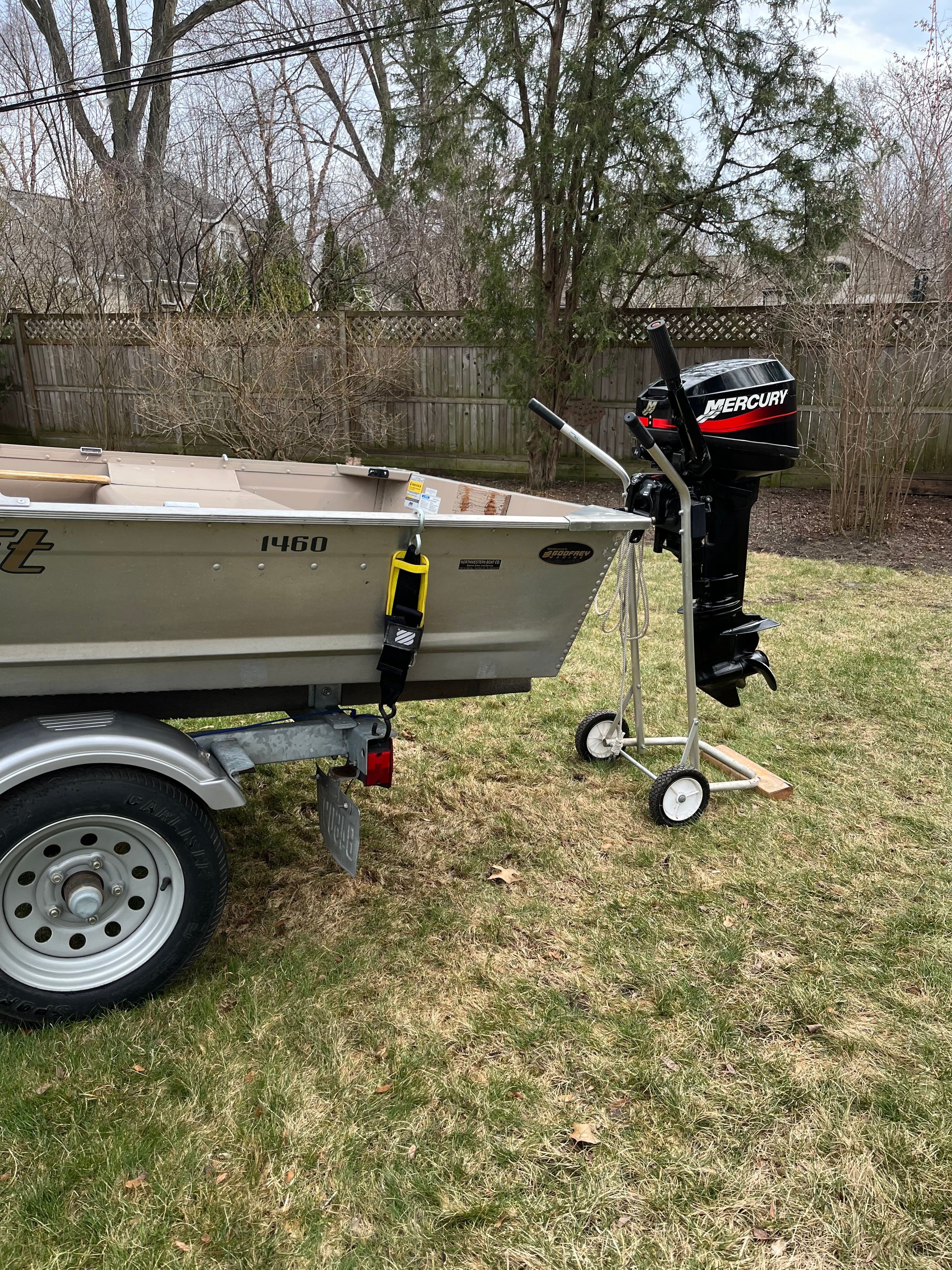 A 2005 Polar Kraft V1460 boat on a trailer in a backyard.