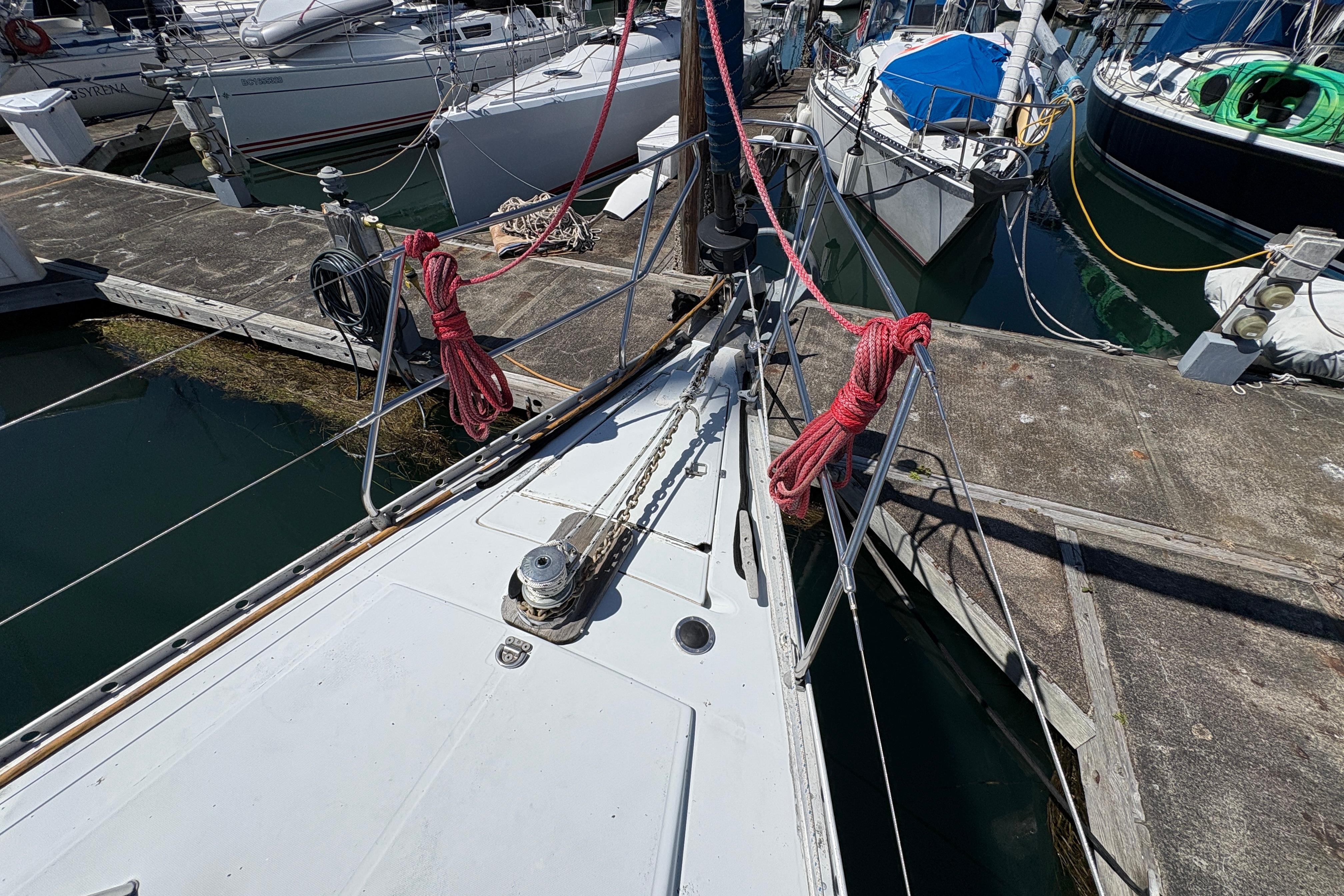 Bow of 1990 Beneteau Oceanis 500 yacht docked at marina with red ropes.
